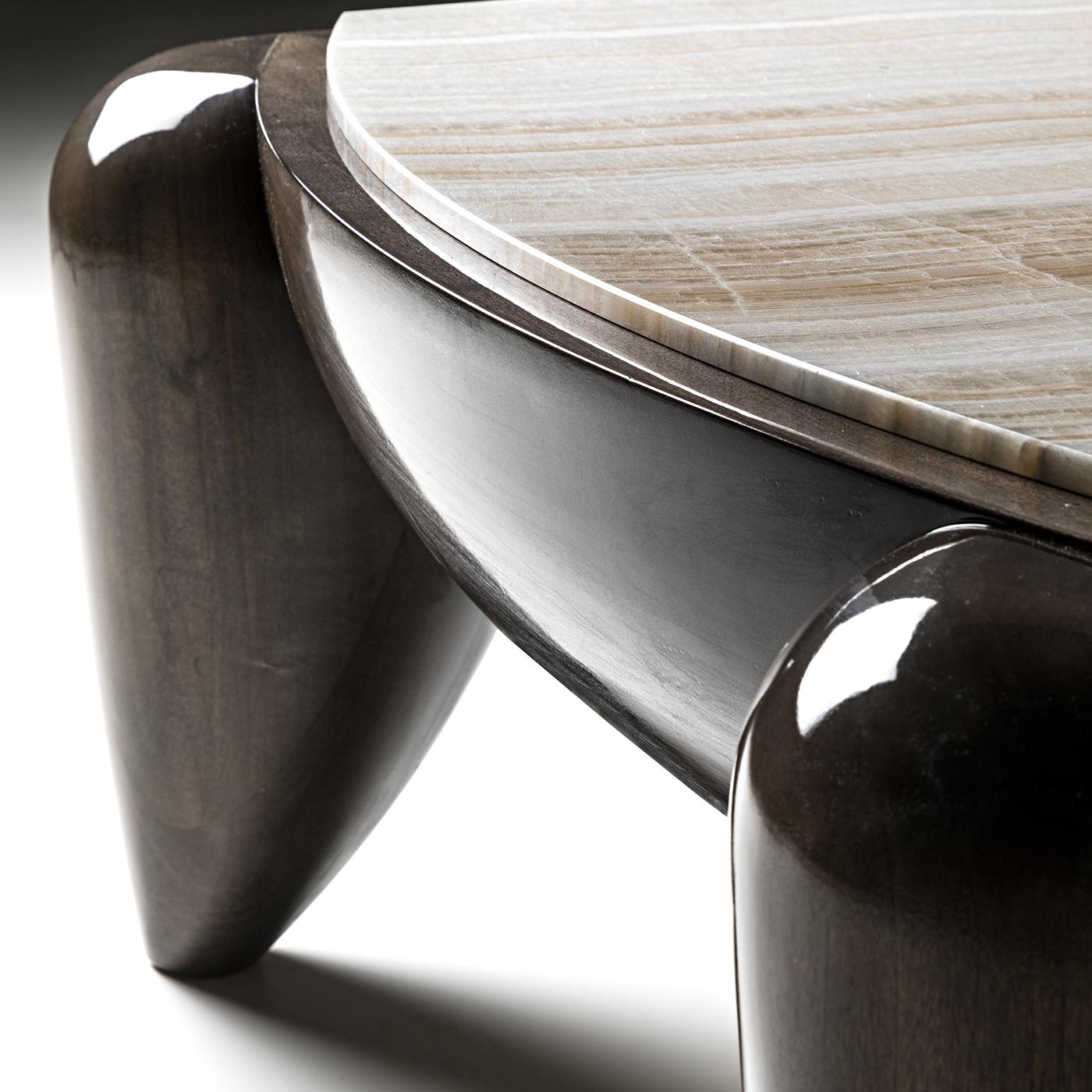 Glossy eucalyptus and prized ivory onyx distinguish the outstanding aesthetic of this elegant coffee table. Delicate and charming, its smooth silhouette showcases a glossy frame in solid eucalyptus with a sophisticated onyx top with convex sides.
