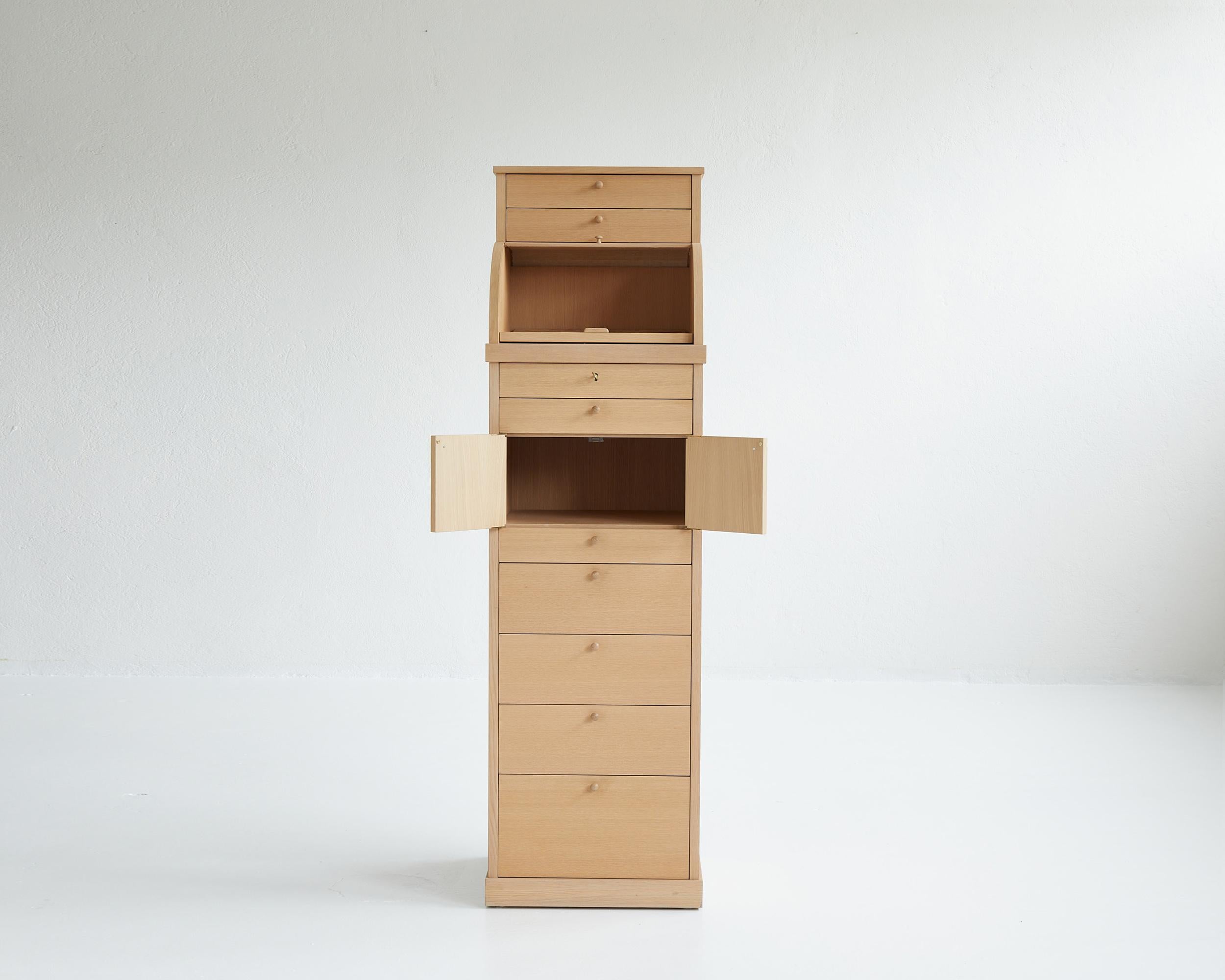 Iconic high drawer cabinet designed by Italian architect and designer Aldo Rossi for Edizioni Molteni in 1987.

The cabinet is composed of a roll top hiding a writing desk that can be pulled out as well as numerous drawers and spaces to classify,