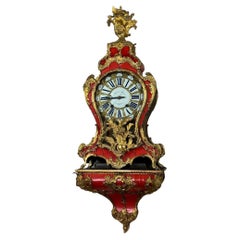 Cartel clock and wall-mounted console in Louis XV style, in red horn