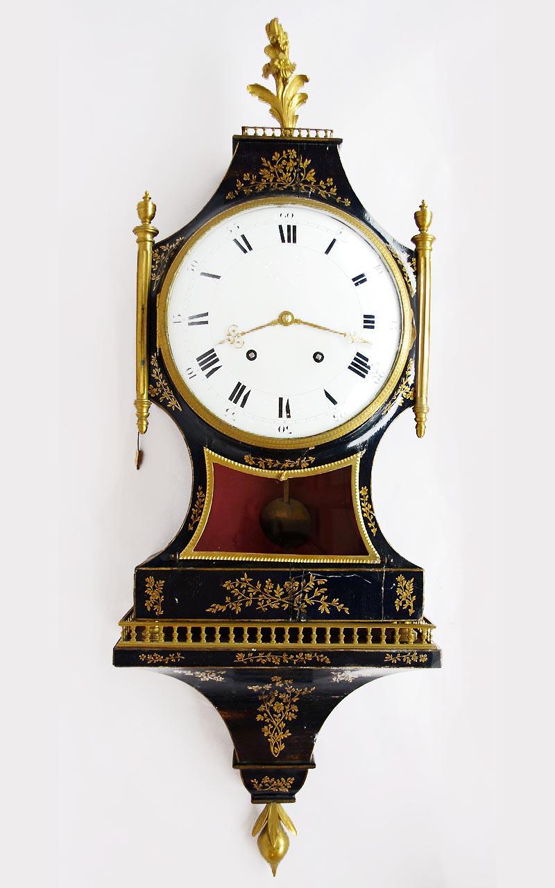 Black lacquered wood and gilt highlights Cartel clock standing on four small gilt brass foot. Case with a gilt decor of foliage motifs, topped by an openwork balcony and crowned by a gilt bronze flowered acanthus leaf stalk motif. Fluted columns