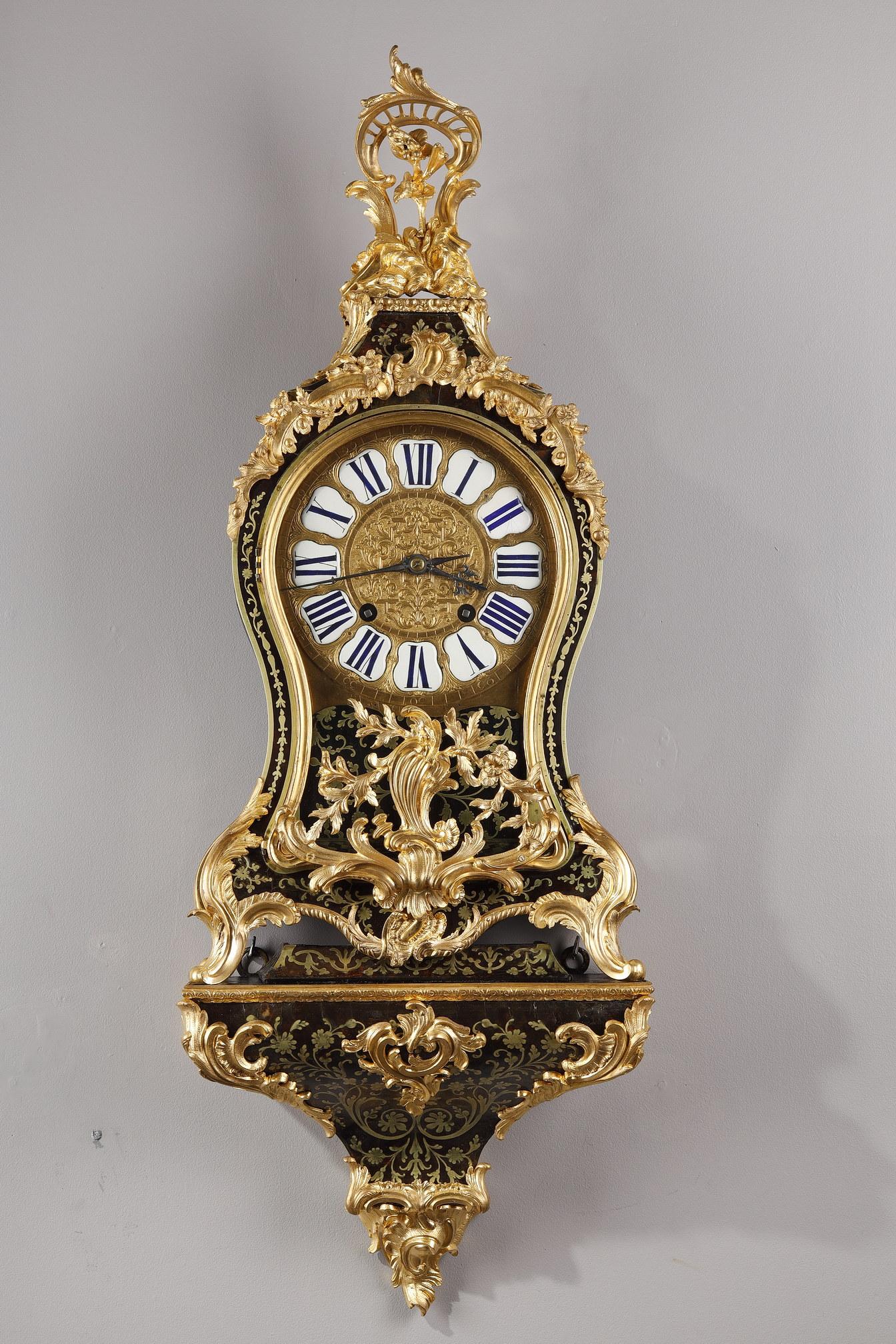 Cartel with its base in Boulle marquetry and gilt bronze. The gilded bronze in moving foliage and scrolls of flowers are of rocaille style. The circular frame in finely chiseled bronze with 12 enamelled cartouches indicating the hours in Roman