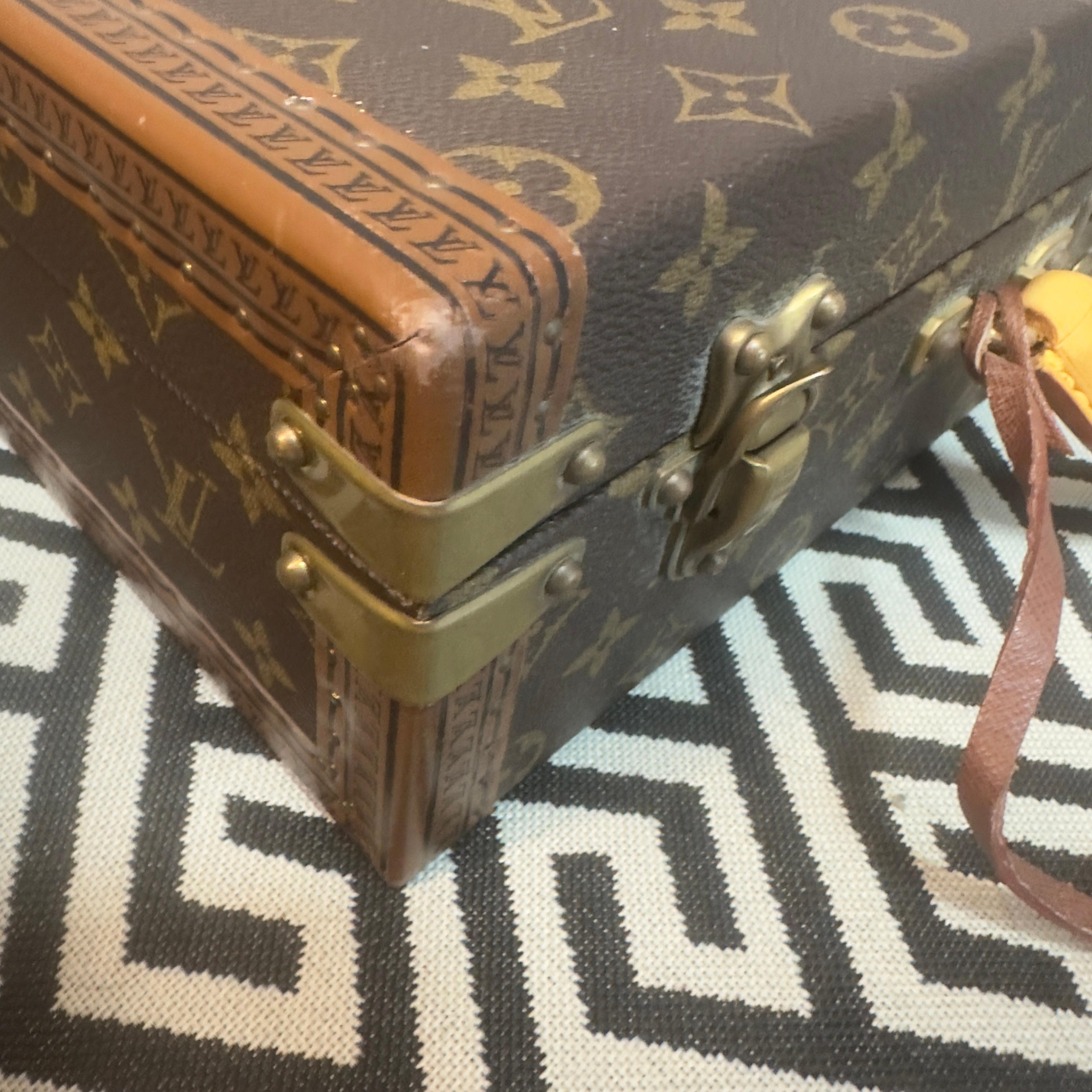 Élégant porte-documents en toile monogrammée Louis Vuitton avec grande poignée en cuir confortable. Fermé par une serrure en laiton massif, il est accompagné de deux loquets en laiton fabriqués à la main. Les bords sont imprimés du logo LV sur tout