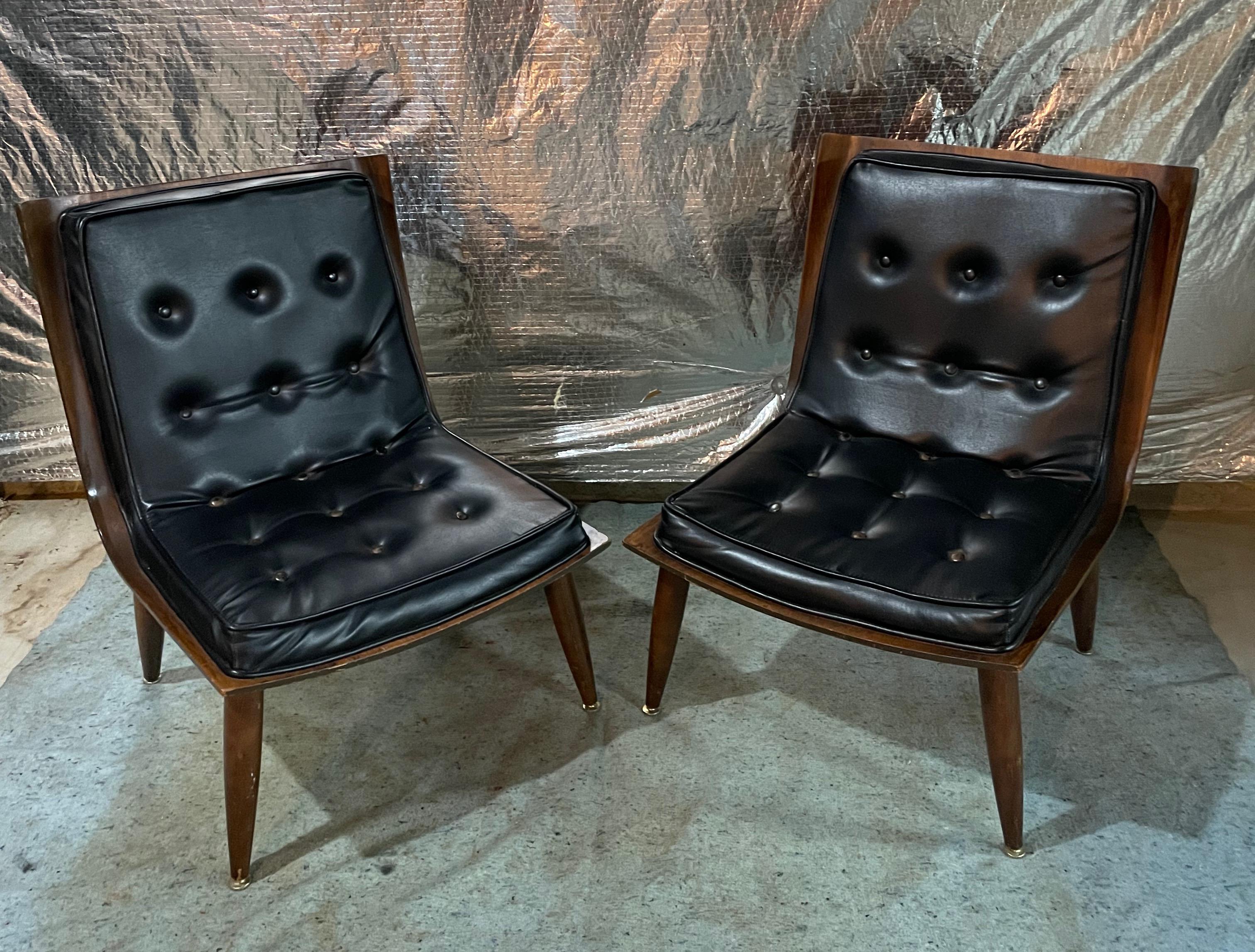 A Classic pair of mid century chairs in bent plywood and faux leather upholstery. These chairs are quintessential mid century.