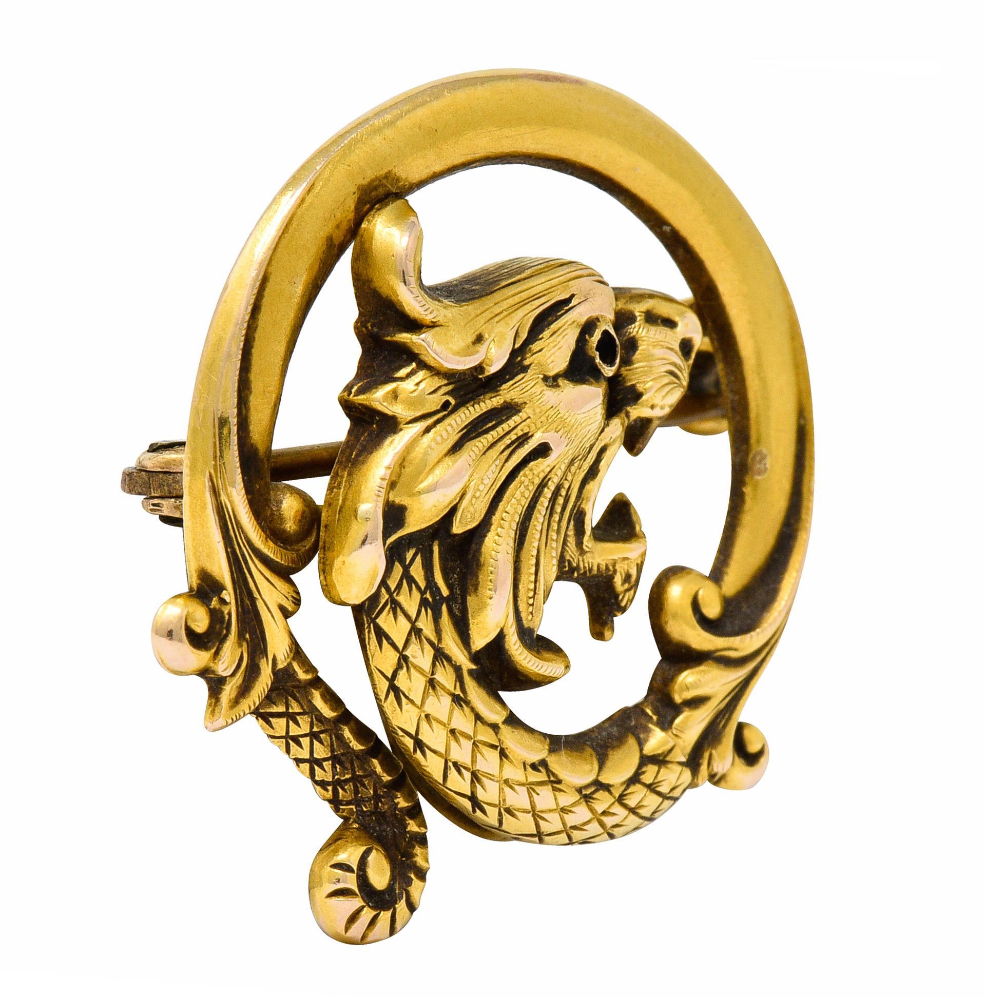 Brooch is designed as a highly rendered roaring lion face

Segueing into a spiraled surround of serpentine scales and foliate whiplash

Completed by a pin stem with closure

Maker's mark for Carter & Gough

Stamped 14K for 14 karat gold

Circa: