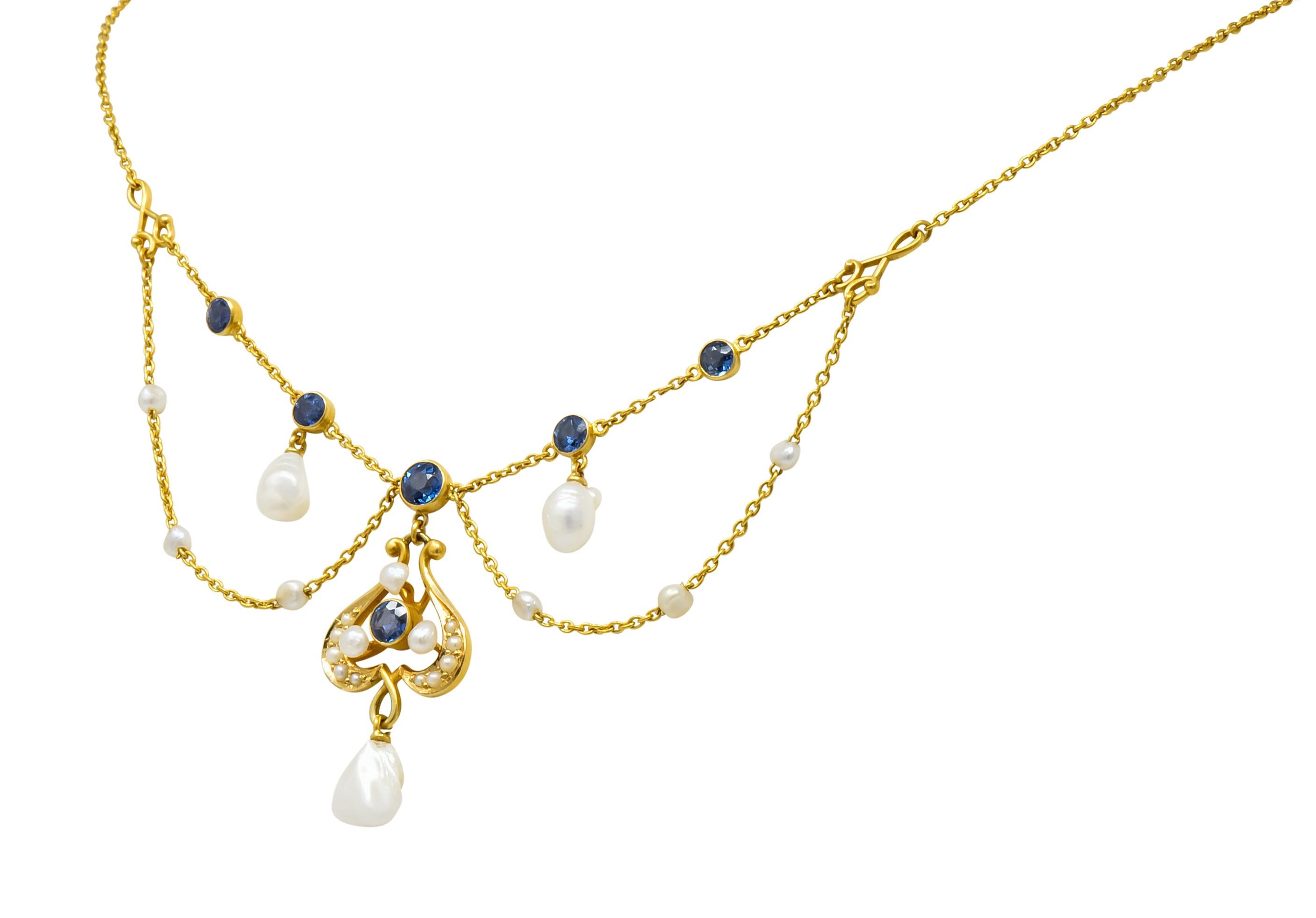 Swag style necklace featuring six bezel set round cut sapphire, transparent and medium-dark in color

With a stylized drop accented by natural seed pearls and three natural baroque pearl drops

Completed by cable chain and spring ring