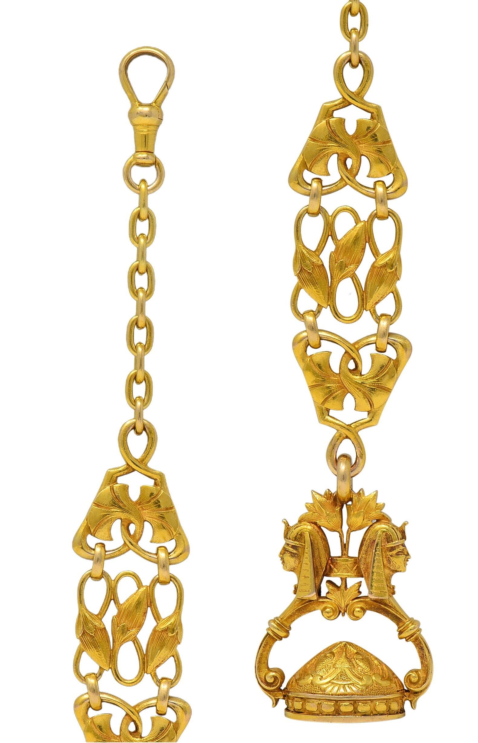 Designed as a watch fob style lobster clasp suspending fancy chain and fob pendant
Chain is cable link with highly rendered panel links connected via jump rings
Depicting sweeping palmettes and lotus blossoms with woven stems
Terminating with fob