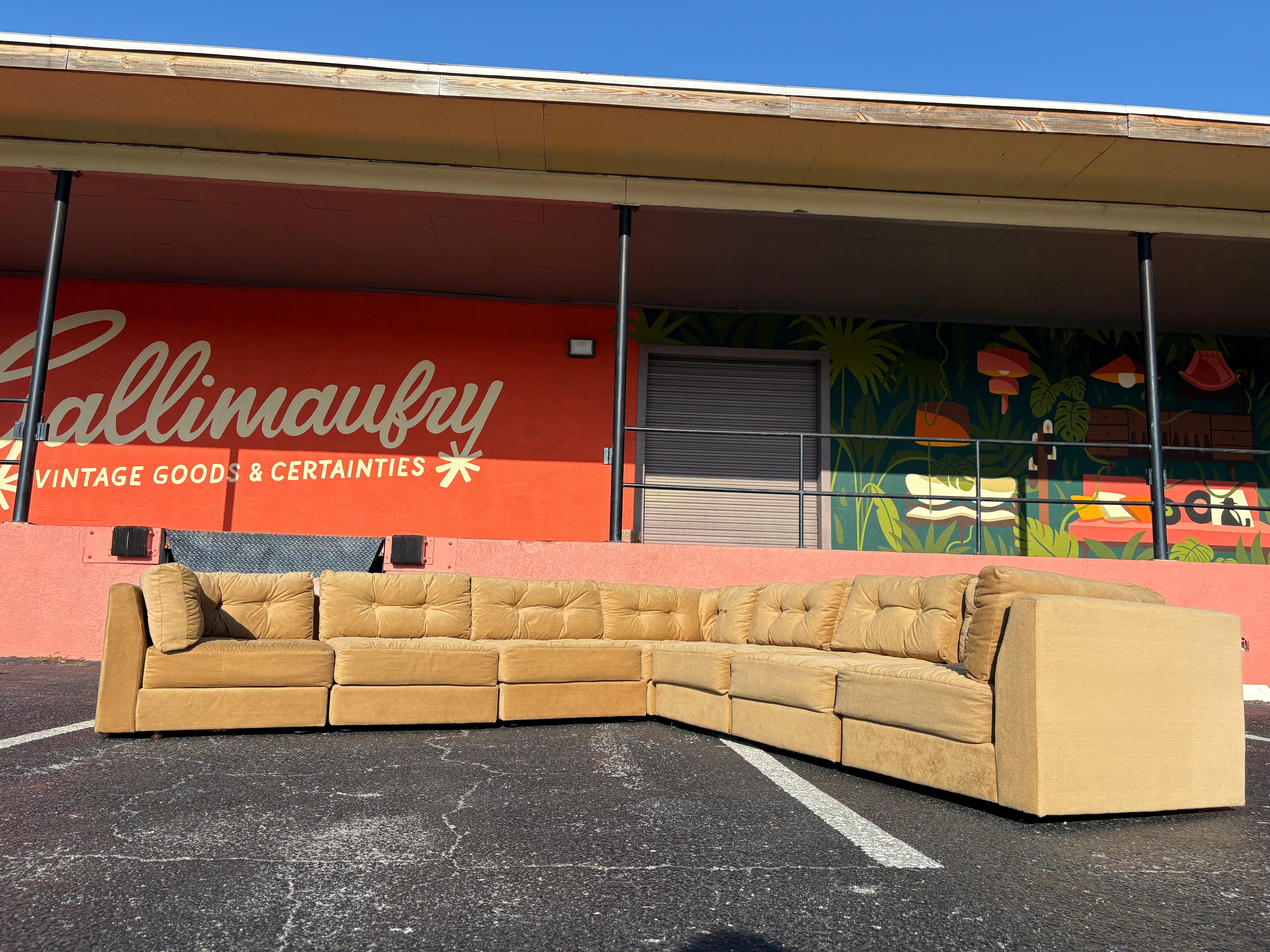 Mid Century Modern Carter Modular Sectional Pit Sofa c.1970’s. Done in the style of Selig Playpen, this warm tan velour modular sectional can be arranged in multiple ways to fit your space. Consists of 3 corner pieces and 4 armless pieces.