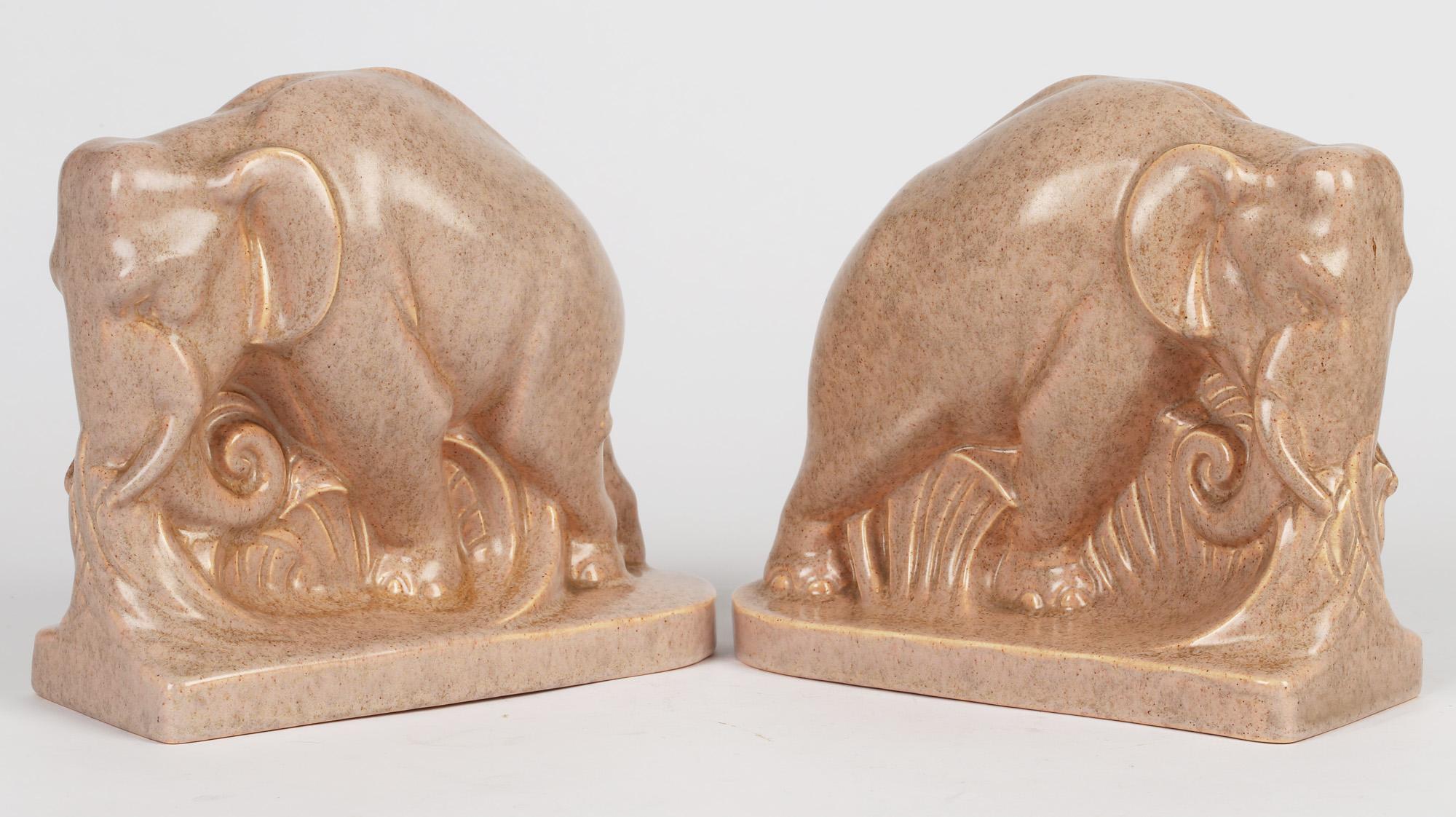A fine and scarce pair Art Deco Carter, Stabler & Adams Poole pottery elephant bookends designed by Harold Brownsworth (1885-1964) and dating from the late 1920's. The elephants stand raised on a shaped base and are well modeled with their heads
