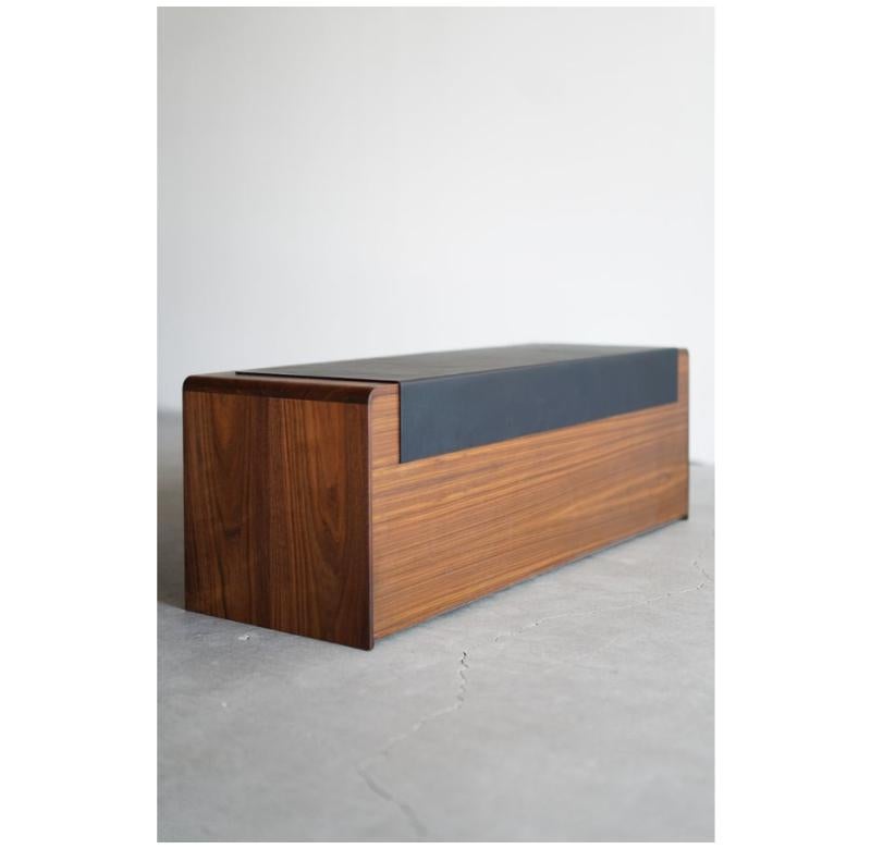 This storage cabinet is custom made in Los Angeles. The solid walnut boards are cut to size and joined. The leather is cut to size and adhered to the wood top. The cabinet has two push-release drawers complimented with a routed wood pull