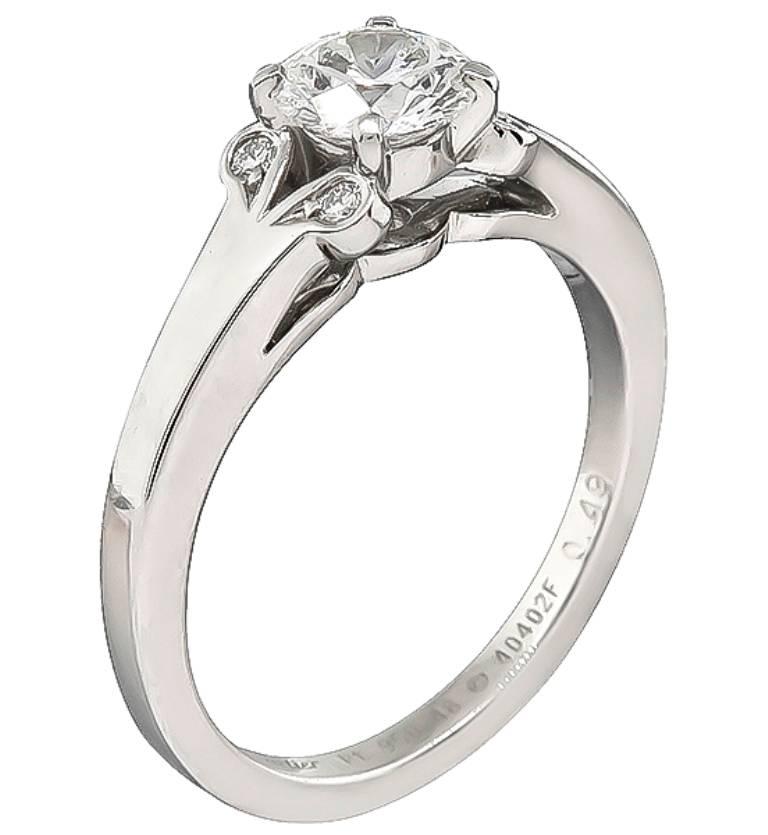 This classic Cartier ring centers with a sparkling GIA certified round brilliant cut diamond that weighs 0.49ct. graded F color with VS2 clarity. The center diamond is accentuated by dazzling round cut diamond accents. The ring is signed Cartier and