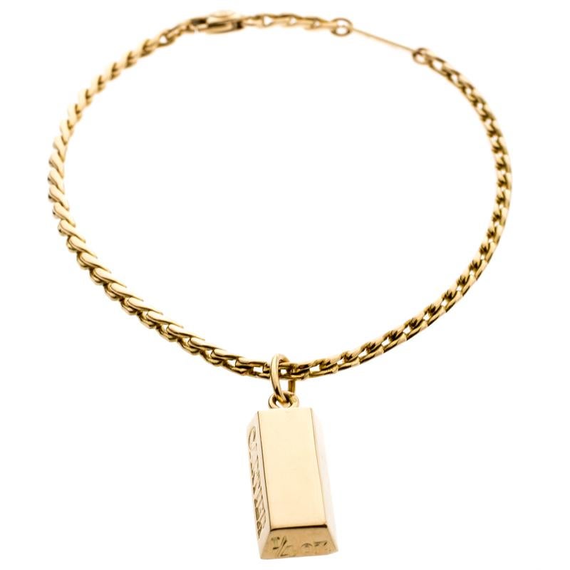 This minimal yet beautiful bracelet from Cartier will make an excellent everyday piece. It is sculpted from 18k yellow gold and features a charm shaped like an ingot. The solid charm is designed with signature engravings at the side and is suspended