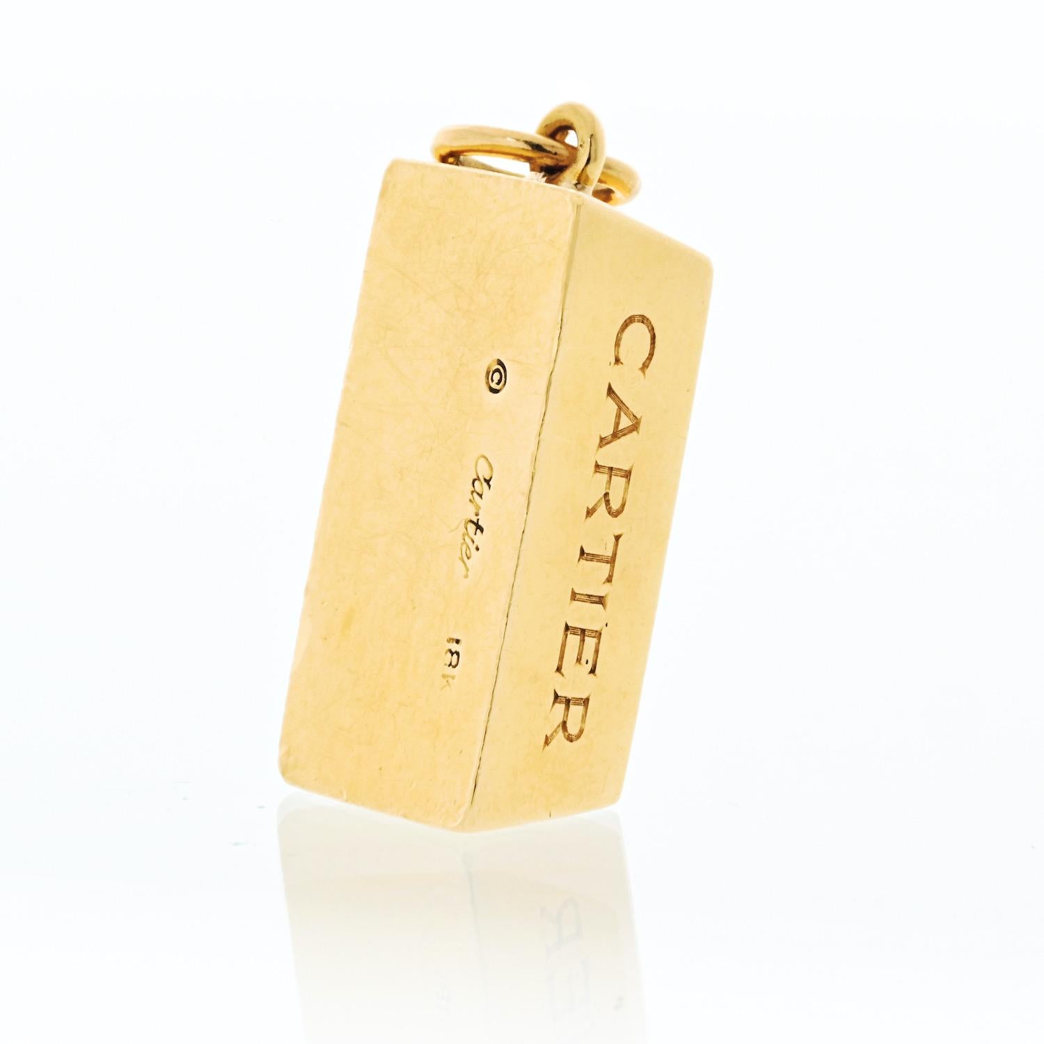 Questo ciondolo vintage di Cartier degli anni '70 è un vero pezzo forte, realizzato in oro giallo 18 carati e disegnato come un classico lingotto. Con un peso di 1 grammo, il ciondolo presenta una finitura lucida ed elegante che emana un'eleganza e