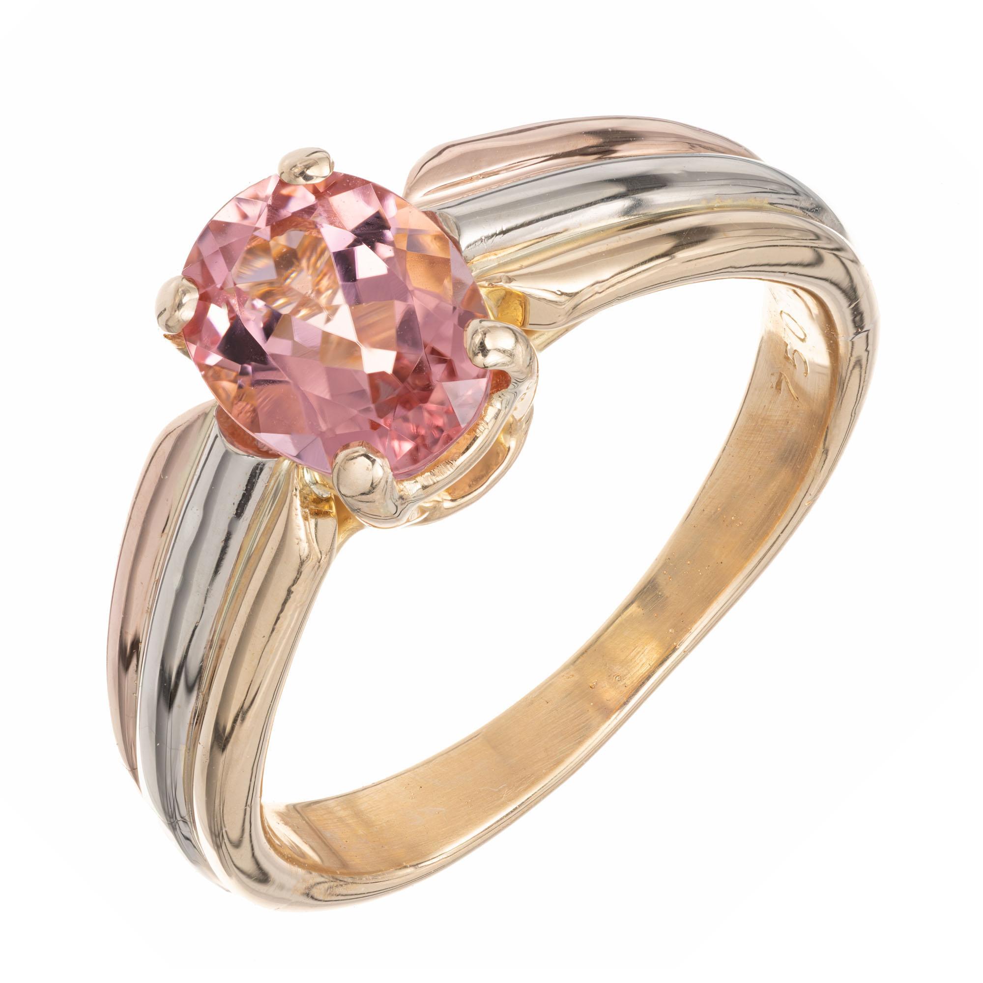 Cartier bright pink oval center tourmaline, in a tri-color, rose, white and yellow gold 18k gold setting. 

1 oval pink tourmaline VS, approx.  1.00ct
Size 6.5 and sizable
18k yellow gold 
Stamped: 750
Hallmark: Cartier
5.3 grams
Width at top: