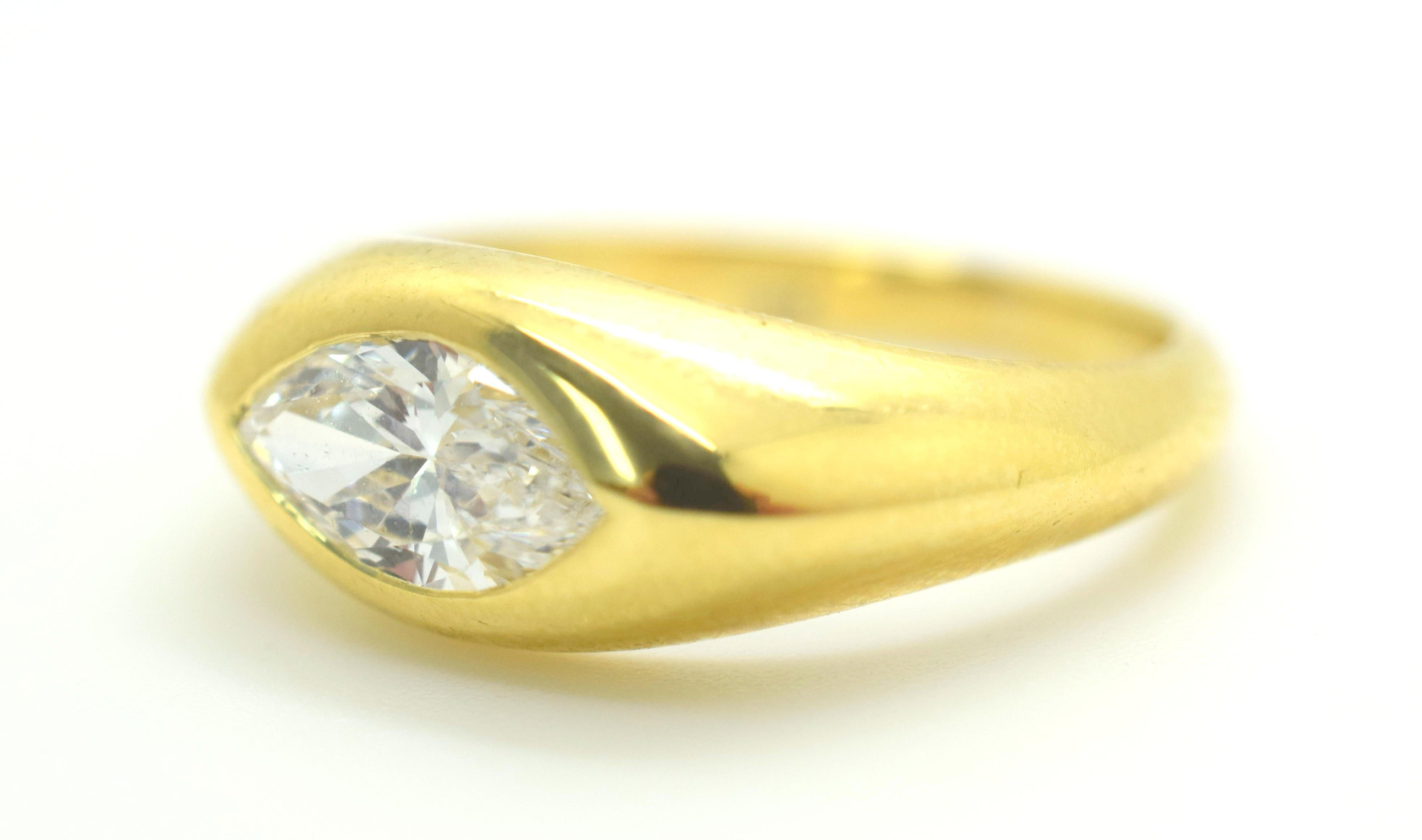 Cartier engagement ring crafted in 18k yellow gold. Ring shows phenomenal detail. The focal point of the ring is a 1.25 Ct. Marquise Cut Natural Diamond with E color and VVS clarity. The Diamond is bezel set flowing flawlessly in the rings design.