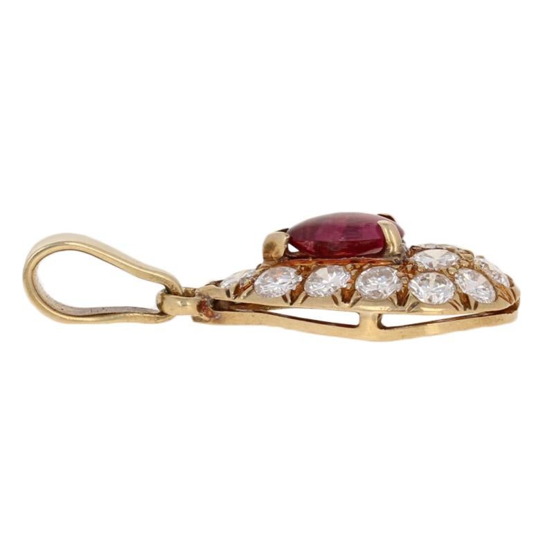 Illuminate the night with a sparkling touch of color! Exquisitely crafted by Cartier, this pear-shaped pendant showcases a vibrant ruby cabochon surrounded by icy white diamonds set in 18k yellow gold. This designer piece retails for $4,000 but it