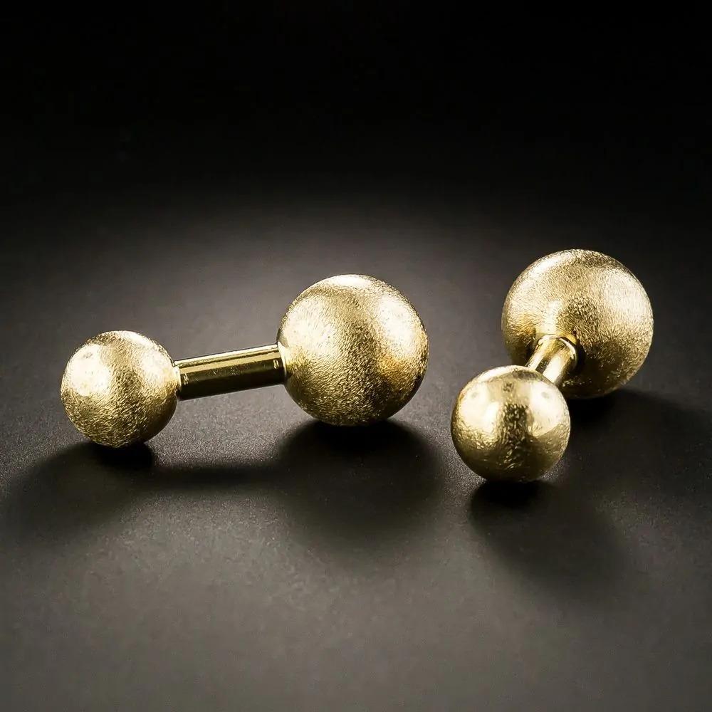Eleva il tuo gioco di accessori con lo squisito set di gemelli e bottoni di Cartier, un mix perfetto di raffinatezza e lusso. Realizzato in oro giallo 14 carati, questo splendido set presenta borchie a sfera d'oro dal design elegante che emanano un