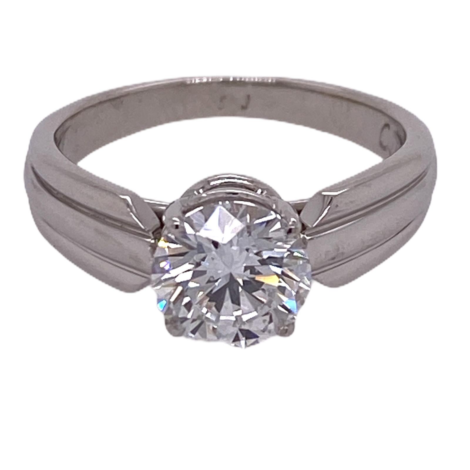 Stunning solitaire diamond engagement ring by Cartier. The round brilliant cut diamond weighs 1.51 carats and is graded E color and VVS2 clarity by the GIA. The certificate and appraisal are in photos. The platinum mounting measures 5mm in width, is