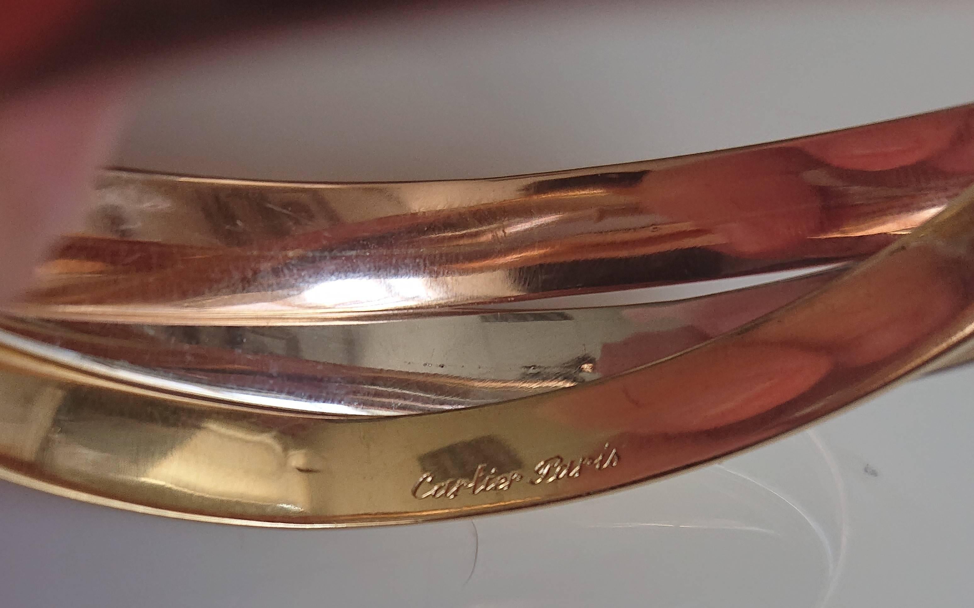 A Cartier 18 Carat Gold Trinity Bangle. Formed of 3 interlocking white gold, rose gold and yellow gold bangles. Signed 