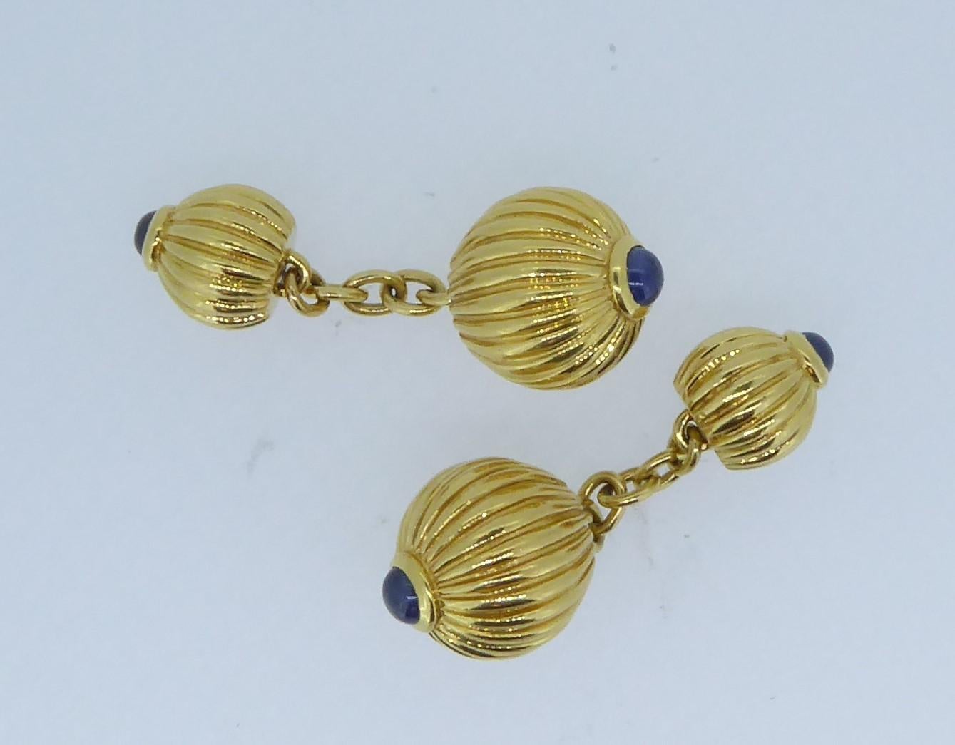 Pair of Cartier 18 Carat Yellow And Blue Sapphire Melon Bead Cufflinks. The four yellow gold ridged each topped with a cabochon blue sapphire. Signed 