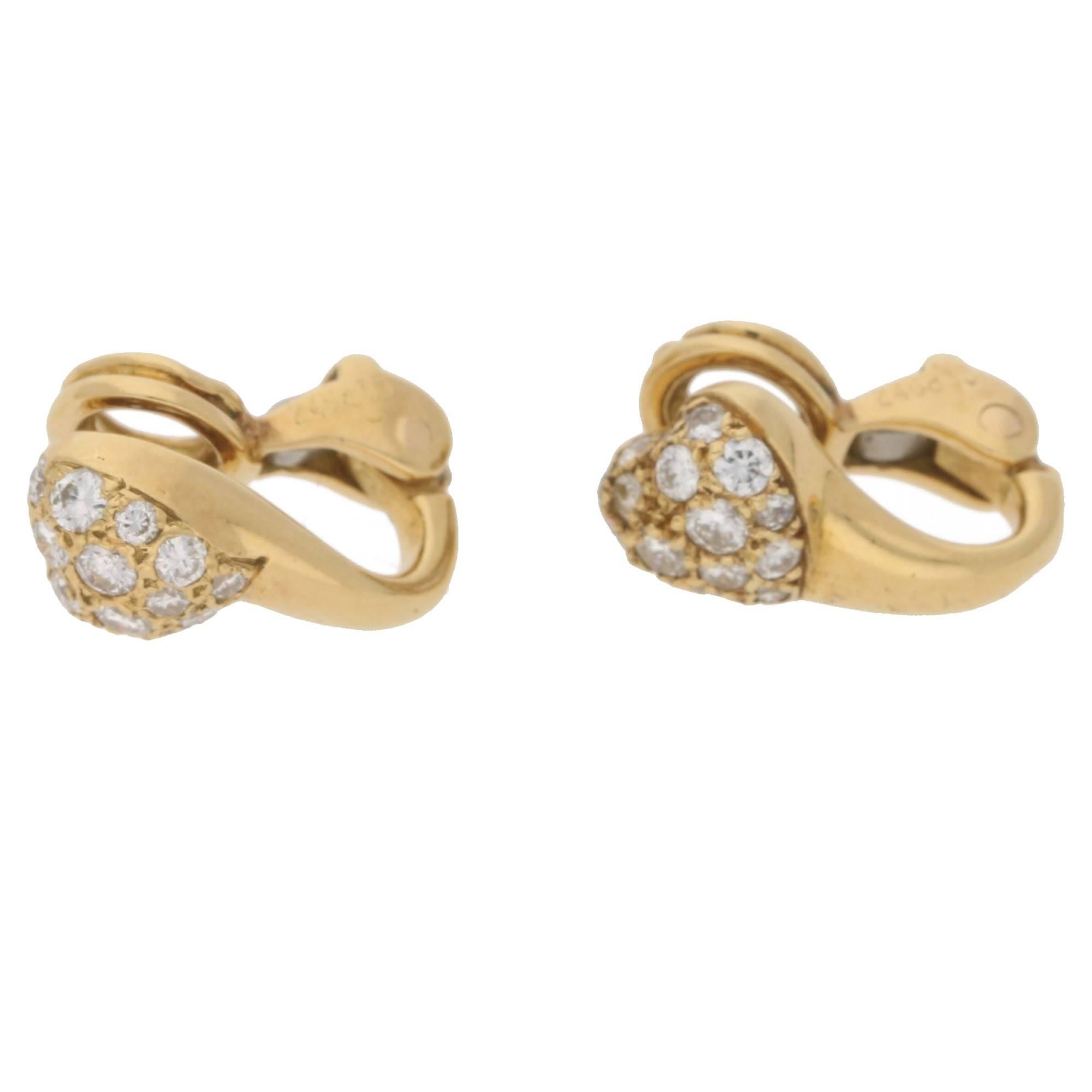 A pair of signed Cartier 18ct yellow gold diamond pavé set heart clip on earrings, featuring 32 round brilliant cut diamonds E/F colour and VVs clarity with an estimated total carat weight of 1.00cts. 
The earrings measure 13x7mm.
