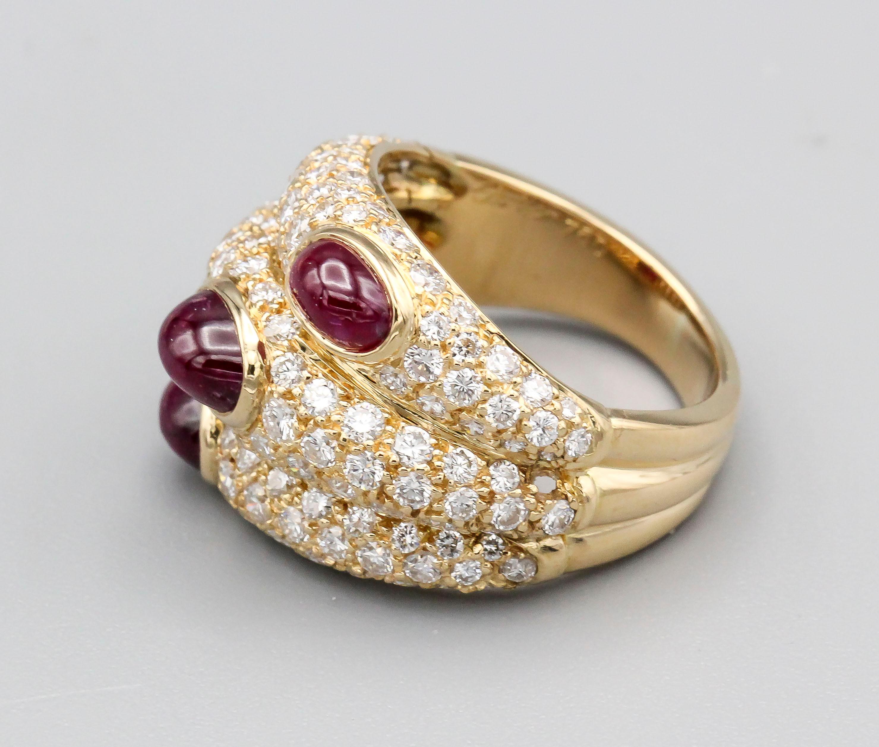 Fine 18k yellow gold ring with pave set diamonds and set with three rich ruby cabochon stones, by Cartier, circa 1990s. The design of the ring is made to look like three rings stacked on top of one another with each ruby cabochon slightly offset