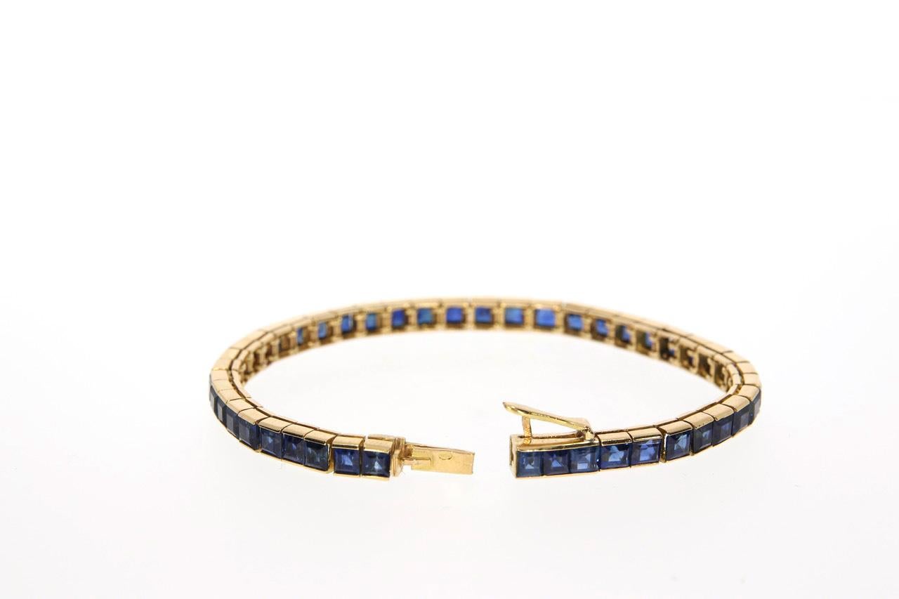 Fine 18 KT, sapphire line bracelet, channel-set with nice bright blue square cuts.
A slightly worn Cartier signature and an 