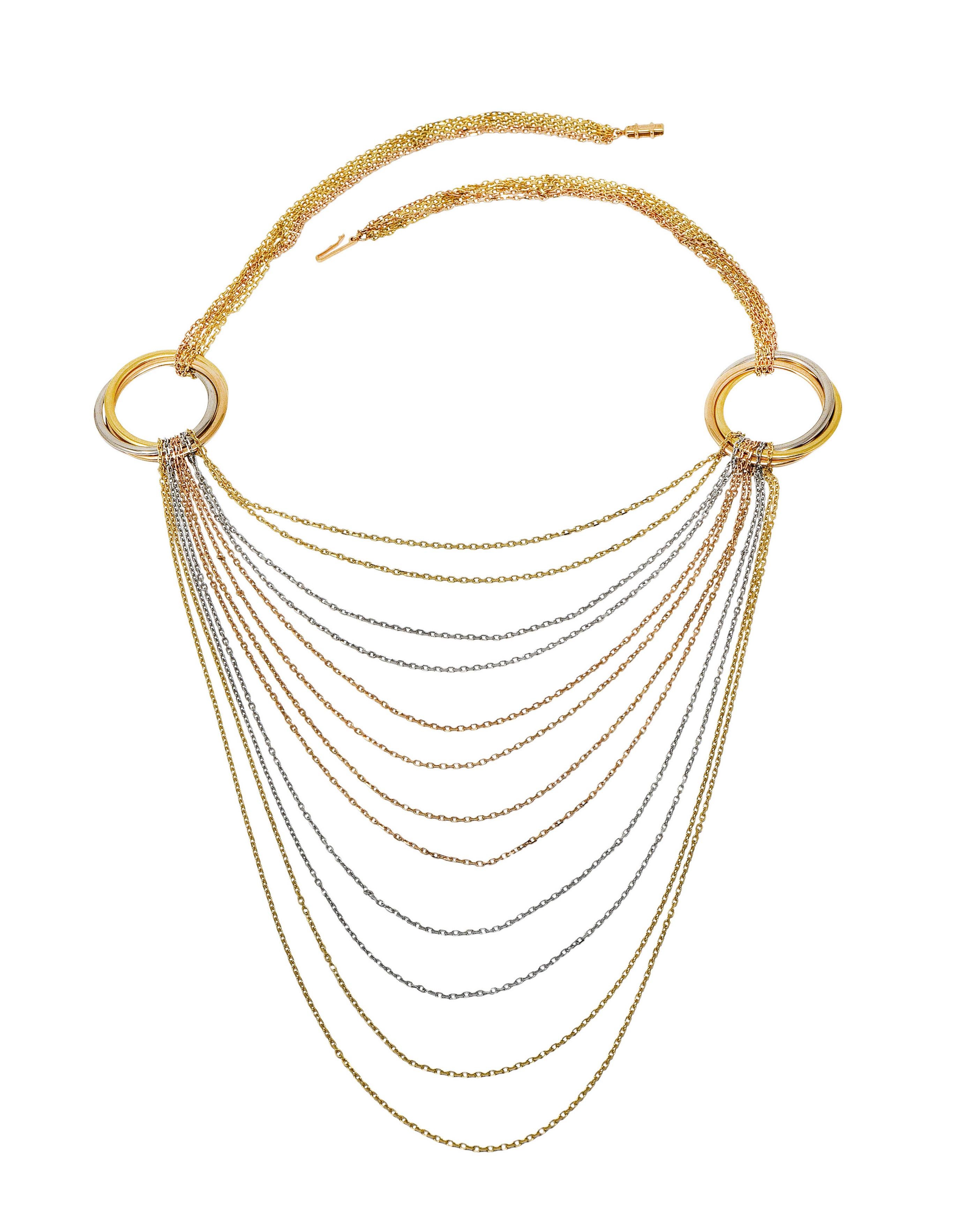 Necklace is comprised of multiple strands of rose, white, and yellow gold chain

With two 35.0 mm circular stations - designed as intertwined tri-colored gold rings

Stations suspend additional chain strands in a swagged drapery style

Completed by