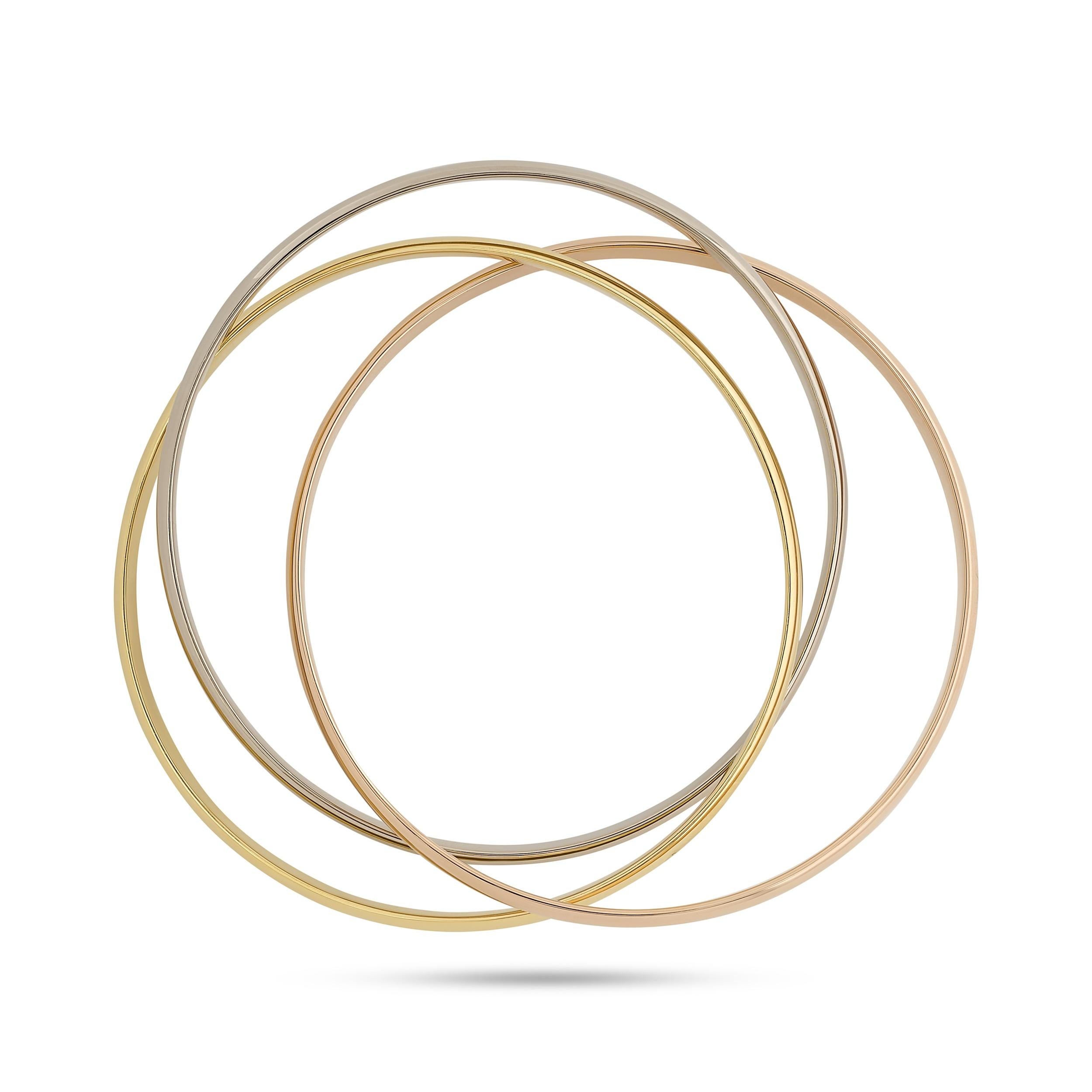 Questo bracciale bangle Trinity in oro 18 carati di Cartier presenta tre bande intrecciate in oro bianco, giallo e rosa che creano un design fluido ed elegante.

Firmato 