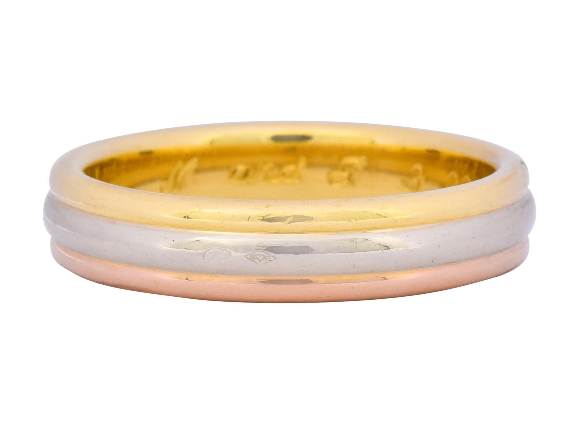 Wide band style ring comprised of three horizontal sections of yellow, white, and rose gold

With a high polished finish and rounded curvature for each section

Inner band with dated inscription

From the Trinity collection

Fully signed Cartier and