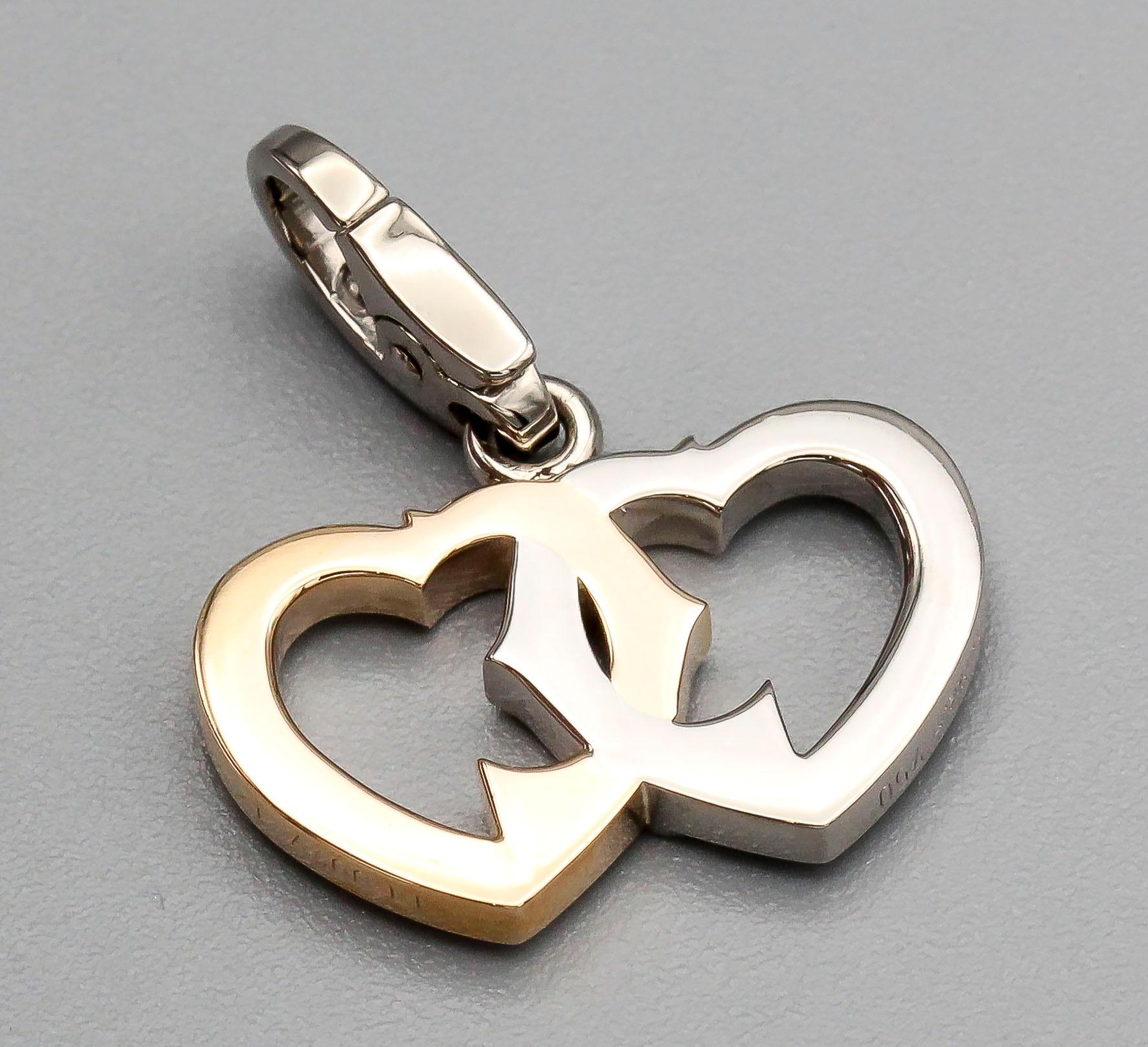 Fine 18k yellow and white gold intertwined double heart logo charm by Cartier.

Hallmarks: Cartier, 750, reference numbers, maker's mark.