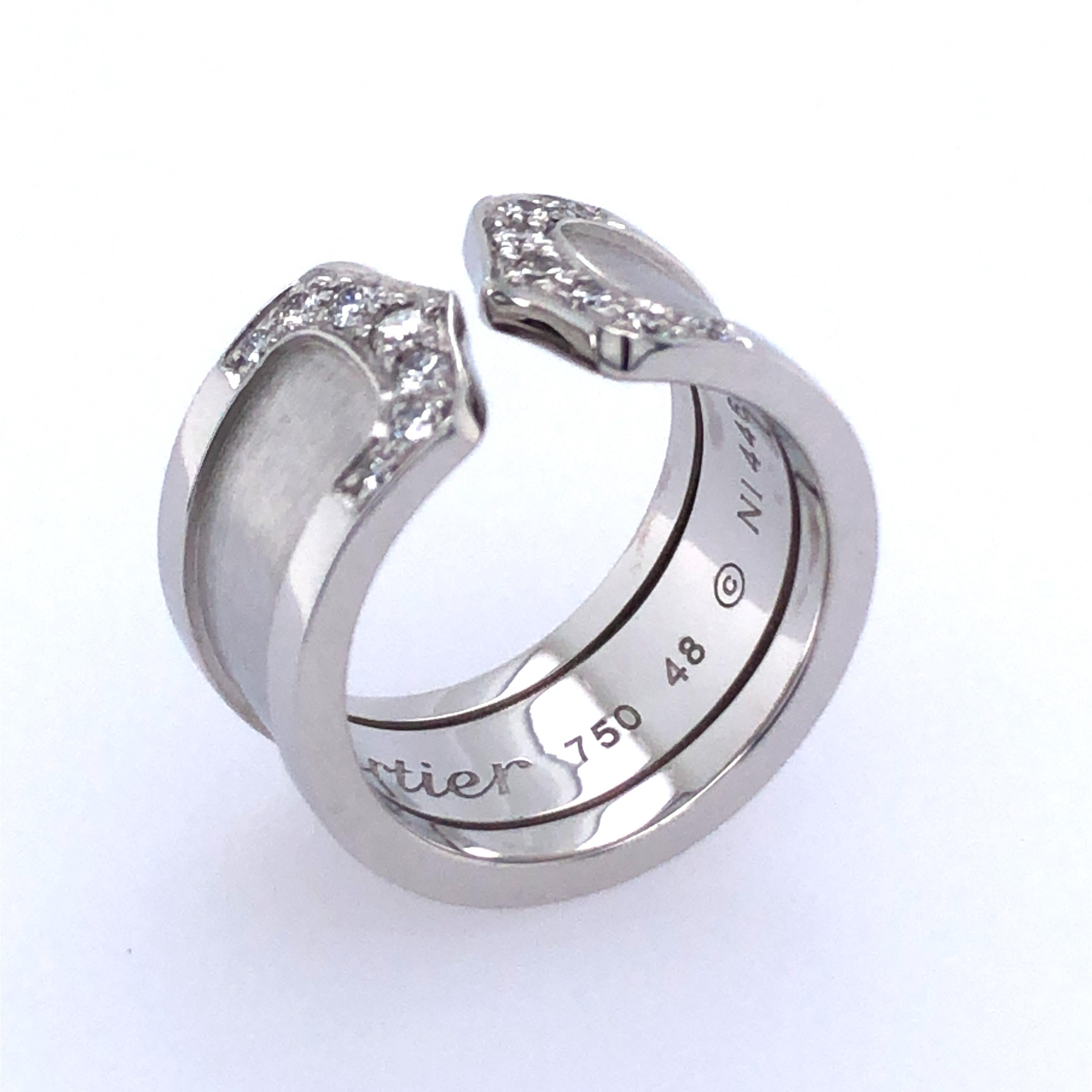Der Ring Cartier Double C ist aus 18 Karat Weißgold gefertigt und mit funkelnden Diamanten besetzt. Der Ring wiegt 10,8 g 7,0 dwt. Ringgröße US 5.0 EU 15.6mm.  Dieses Schmuckstück wird im Nachlasszustand angeboten und enthält das Zertifikat des