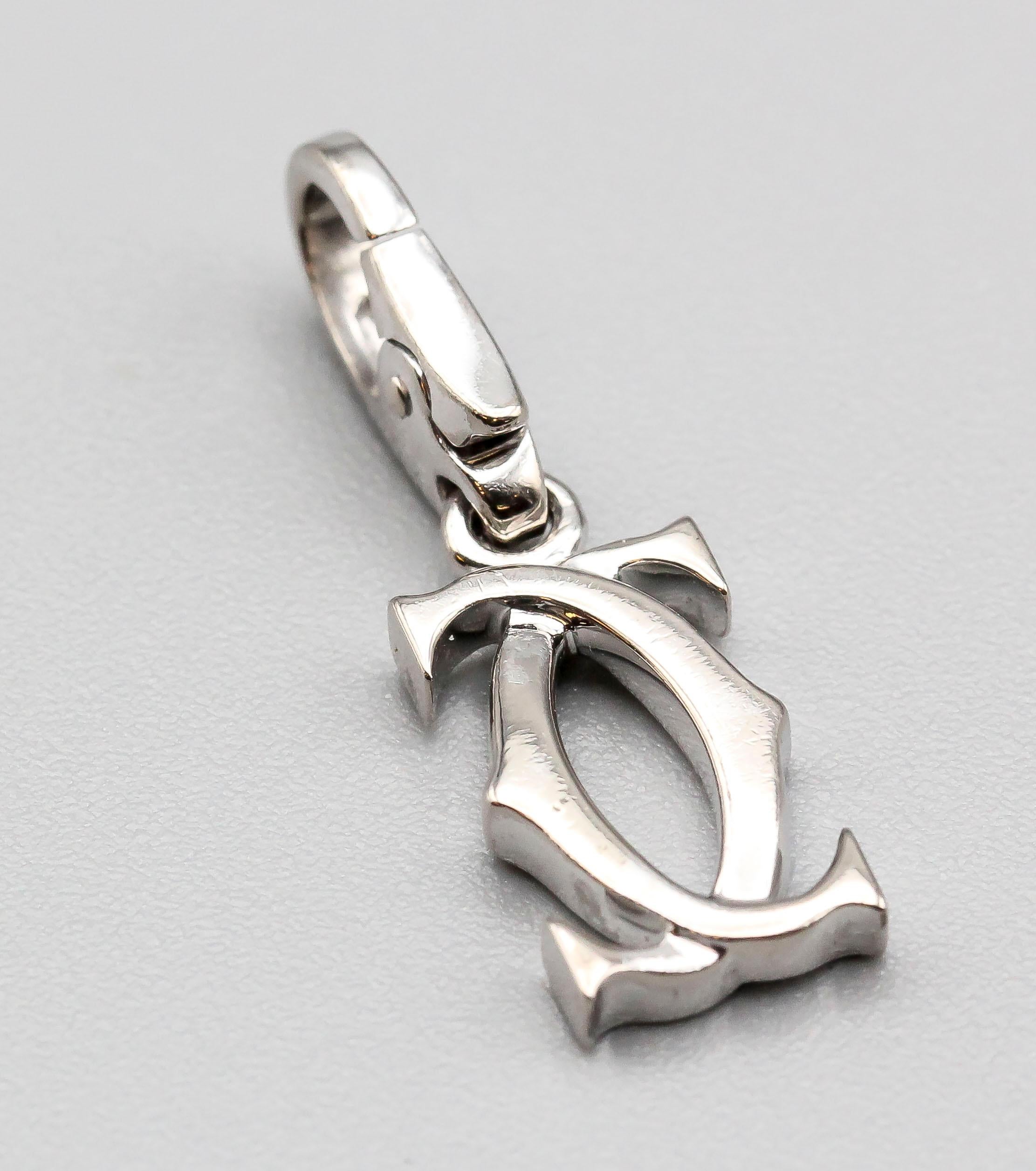 Fine 18K white gold charm by Cartier. It features the Cartier 