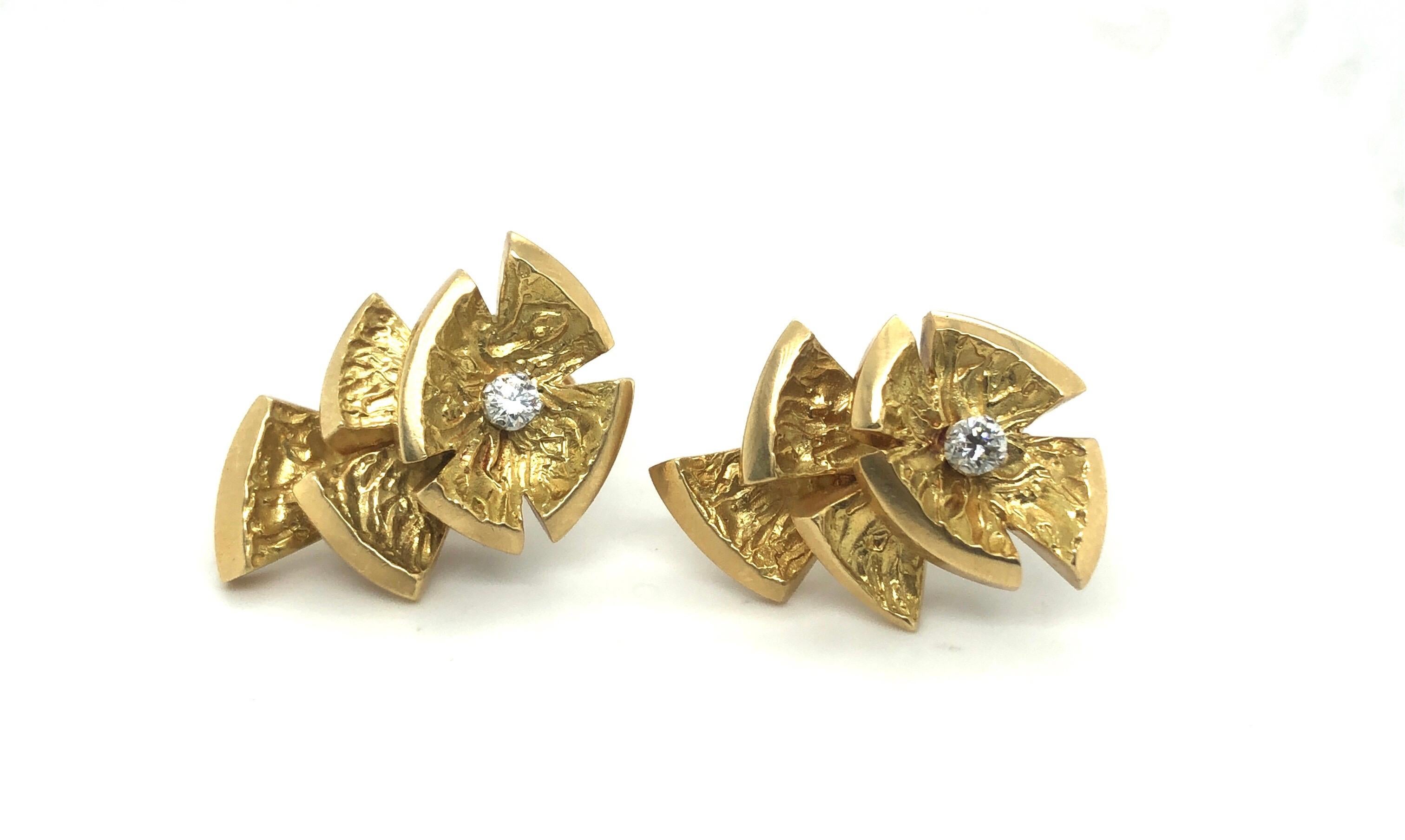 Stylish pair of 18 karat yellow gold and diamond earrings by André Vassort for Cartier, 1970s.
Crafted in 18 karat yellow gold and designed as stylized flowers with structured petals, each of the earrings is centered by a brilliant-cut diamond of