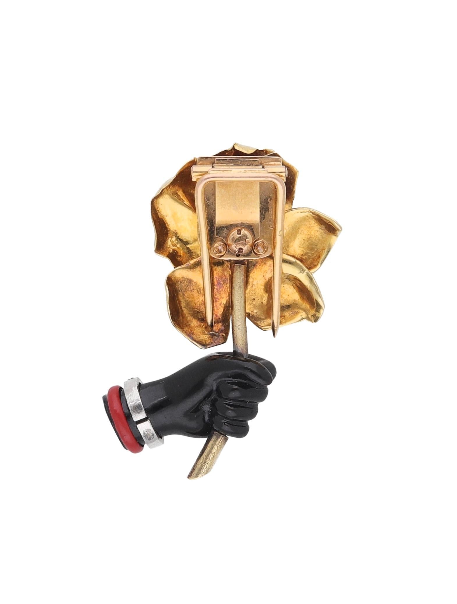 Spilla realizzata in oro giallo 18 kt. con diamanti e onice firmata Cartier.
Questa spilla raffigurante una mano che tiene un fiore risale al 1940 ca.
Scatola originale.

Diamante taglio brillante ct. 0.45 ca.
Peso: gr. 18,00
Lunghezza: cm. 4.00