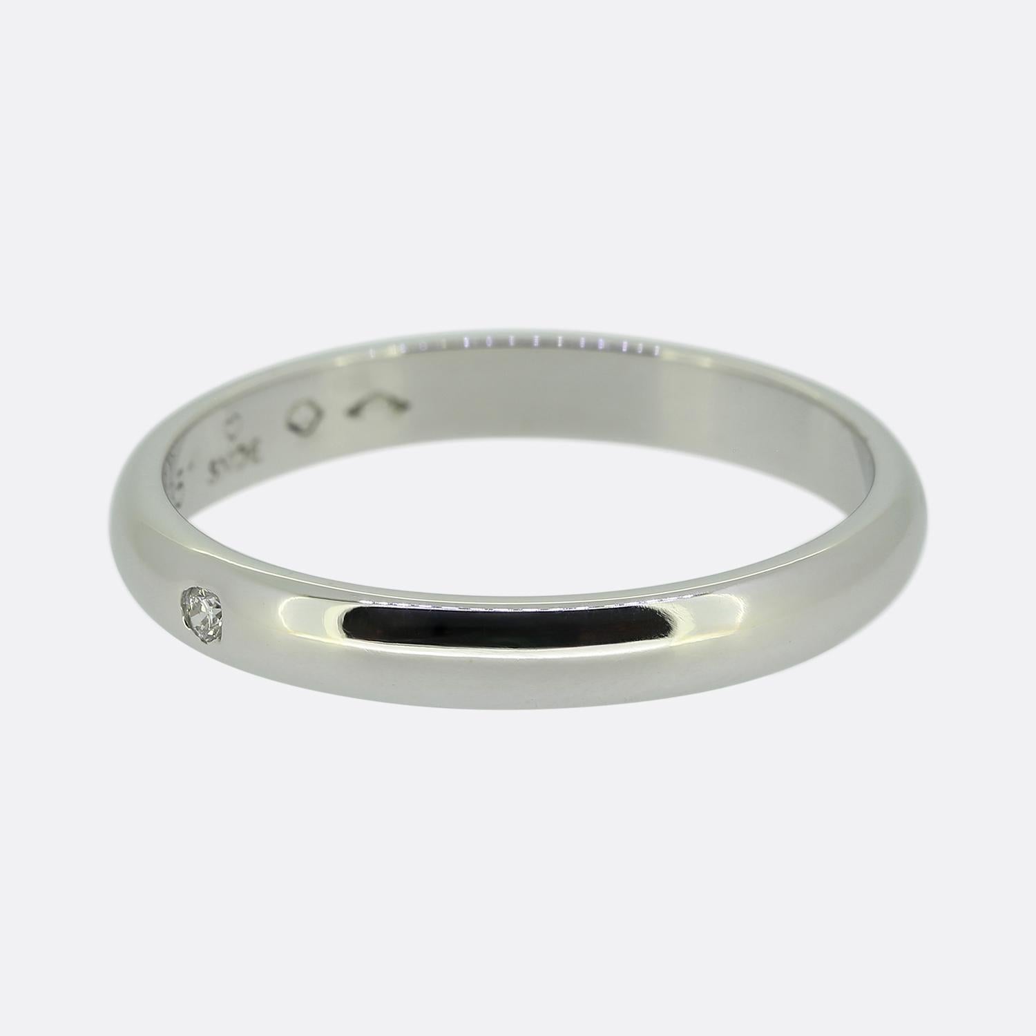 Hier haben wir einen eleganten Platinring aus dem weltbekannten Schmuckhaus Cartier. Das Design zeichnet sich durch einen einzelnen, strahlend weißen, runden Diamanten im Brillantschliff aus, der dezent in die glatte, polierte Oberfläche des Bandes