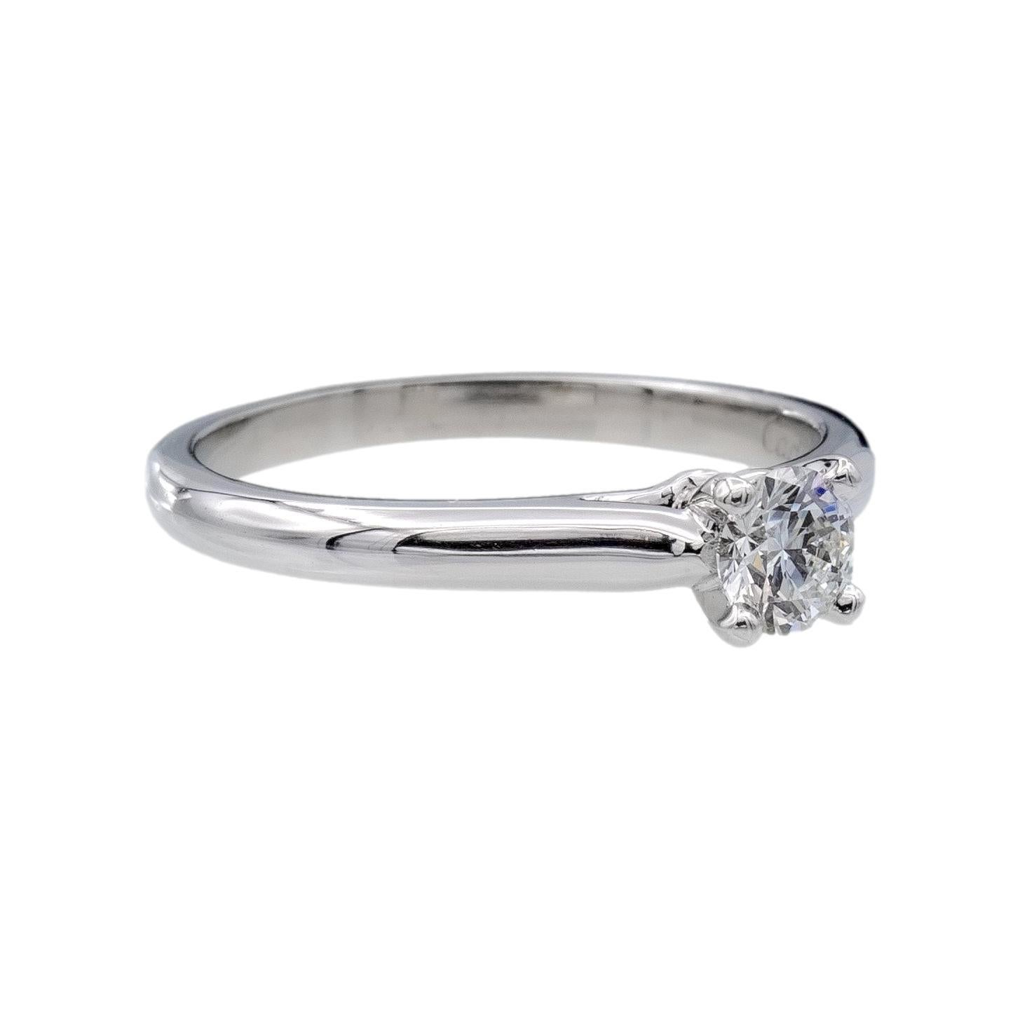 Dieser Verlobungsring von Cartier aus der Collection'S 1895 ist ein Meisterwerk der Handwerkskunst, gefertigt aus hochwertigem Platin mit einem atemberaubenden runden Brillanten von 0,25 Karat in der Mitte. Der Diamant wurde vom renommierten