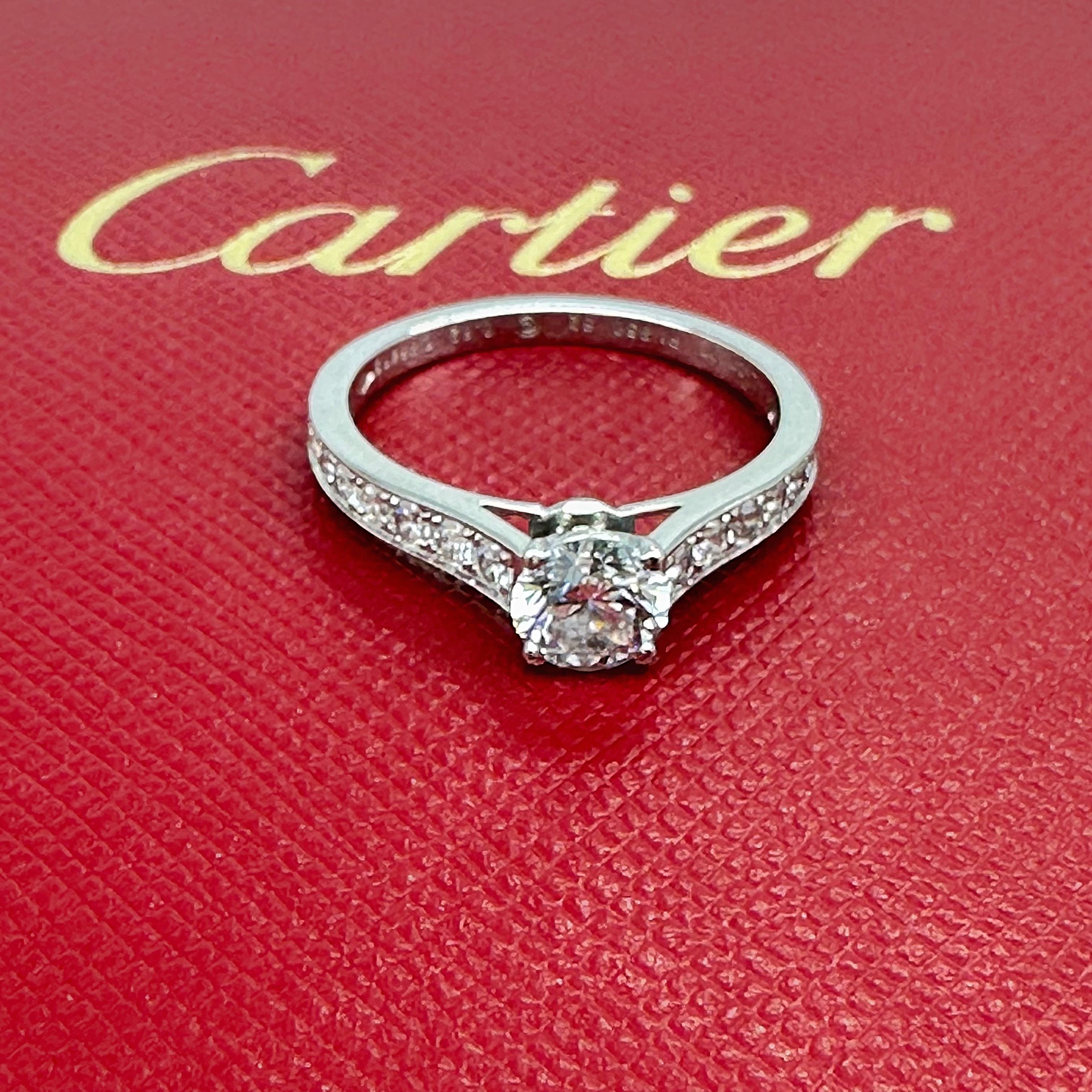 Cartier 1895 Diamond Engagement Ring
Style:  Solitaire with Diamond Accents
Ref. number:  QF****
Metal:  Platinum PT950
GIA:  2106981161
Size:  6.25
TCW:  0.88 tcw
Main Diamond:  Round Brilliant Diamond 0.62 cts
Color & Clarity:  E, VVS2
Accent