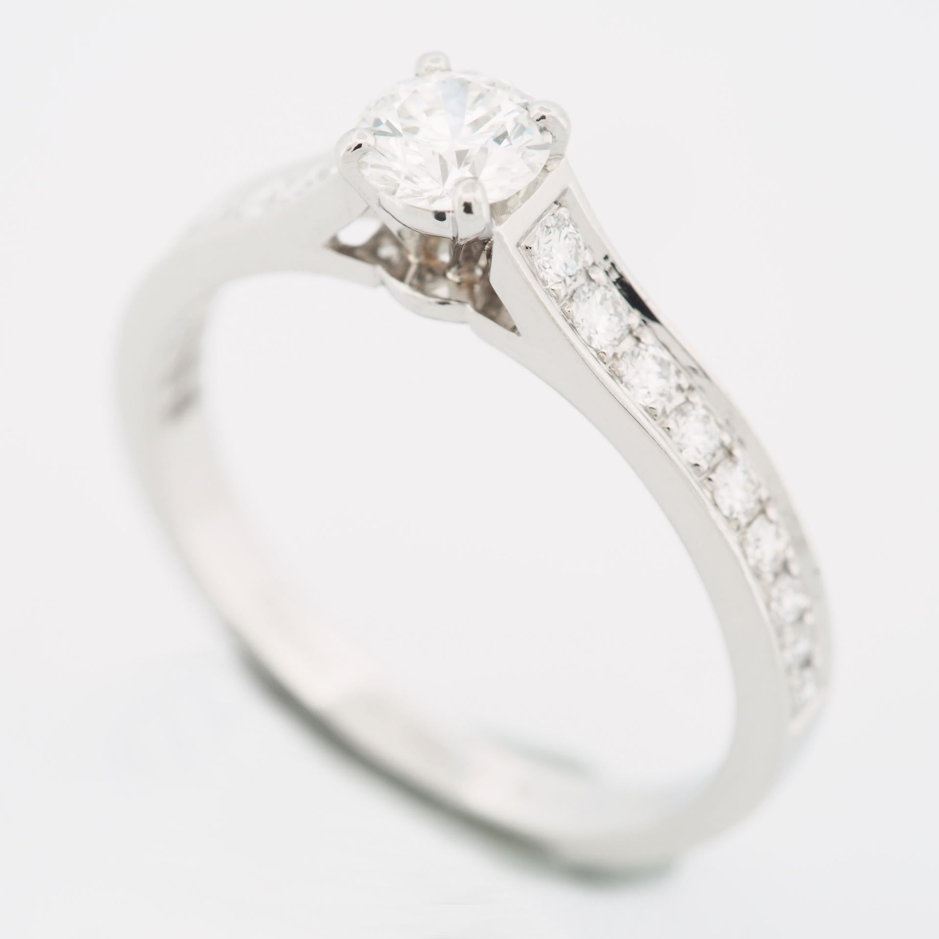 Item: Authentic Cartier 1895 Diamond Solitaire Ring
Stones: Diamond ( center stone 0.32 ct ) with 18 pave diamonds
Color: G
Clarity: VVS1
Polish: Excellent 
Symmetry: Excellent
Fluorescence: None
Metal: Platinum 950
Ring Size: 50 US SIZE 5.25 UK