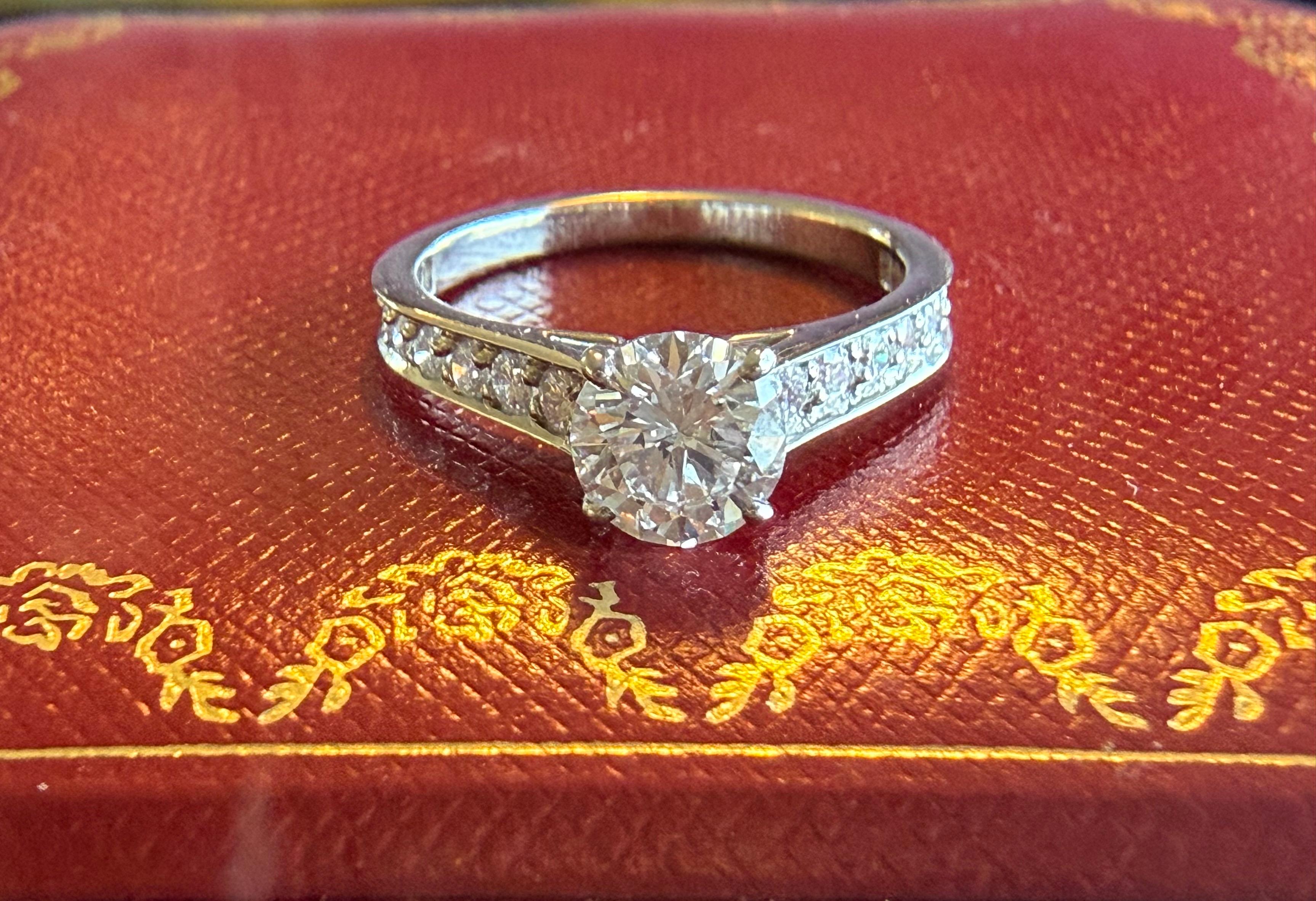 Anello di fidanzamento con diamante di Cartier 
Pietra centrale .96 ct Diamante rotondo taglio Brilliante.
D. A.
Diamanti in platino Pave nell'anello .30cts + .96 centrale 
Platino Classico Pave Taglio Brilliante 
rif. N4160800
Numero di serie