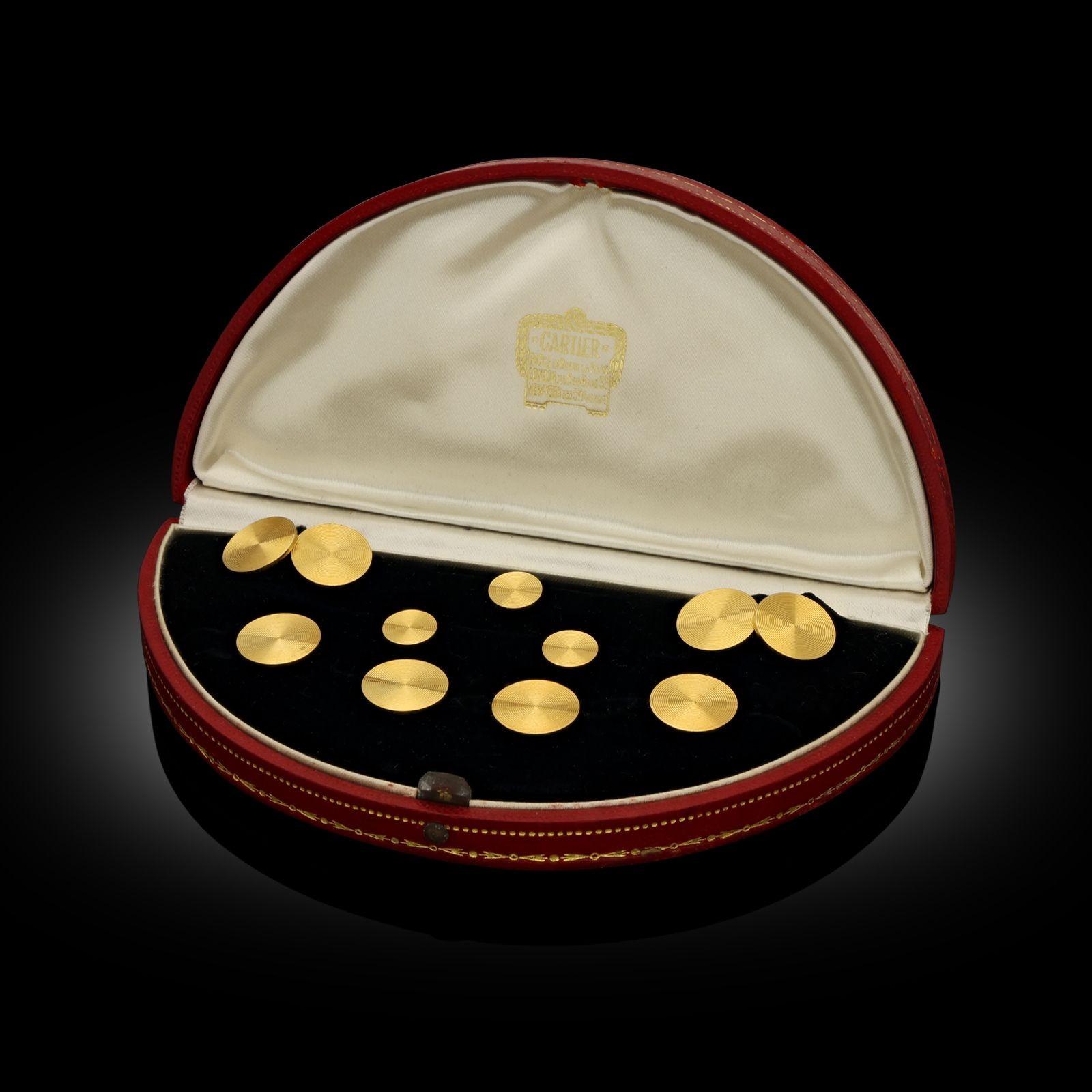 An elegant 18ct gold gentleman’s dress set by Cartier c.1920s, composed of a pair of matching cufflinks, four buttons and three shirt studs, all designed with circular heads fully engraved with concentric circles, the cufflinks double ended and with