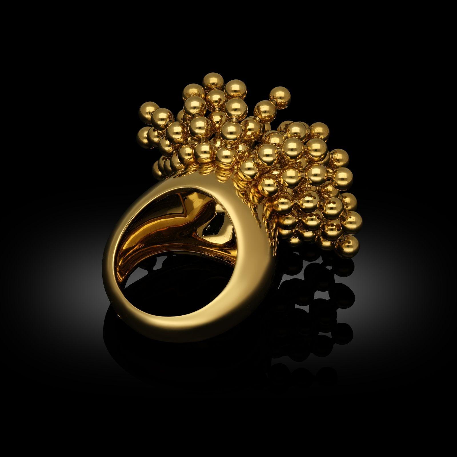 An 18ct yellow gold 'Perruque' cocktail ring by Cartier c.2020, from their ‘Paris Nouvelle Vague’ collection, the wide gold domed band supporting a highly articulated mass of gold spheres strung together to form a pom-pom style tassel cluster which