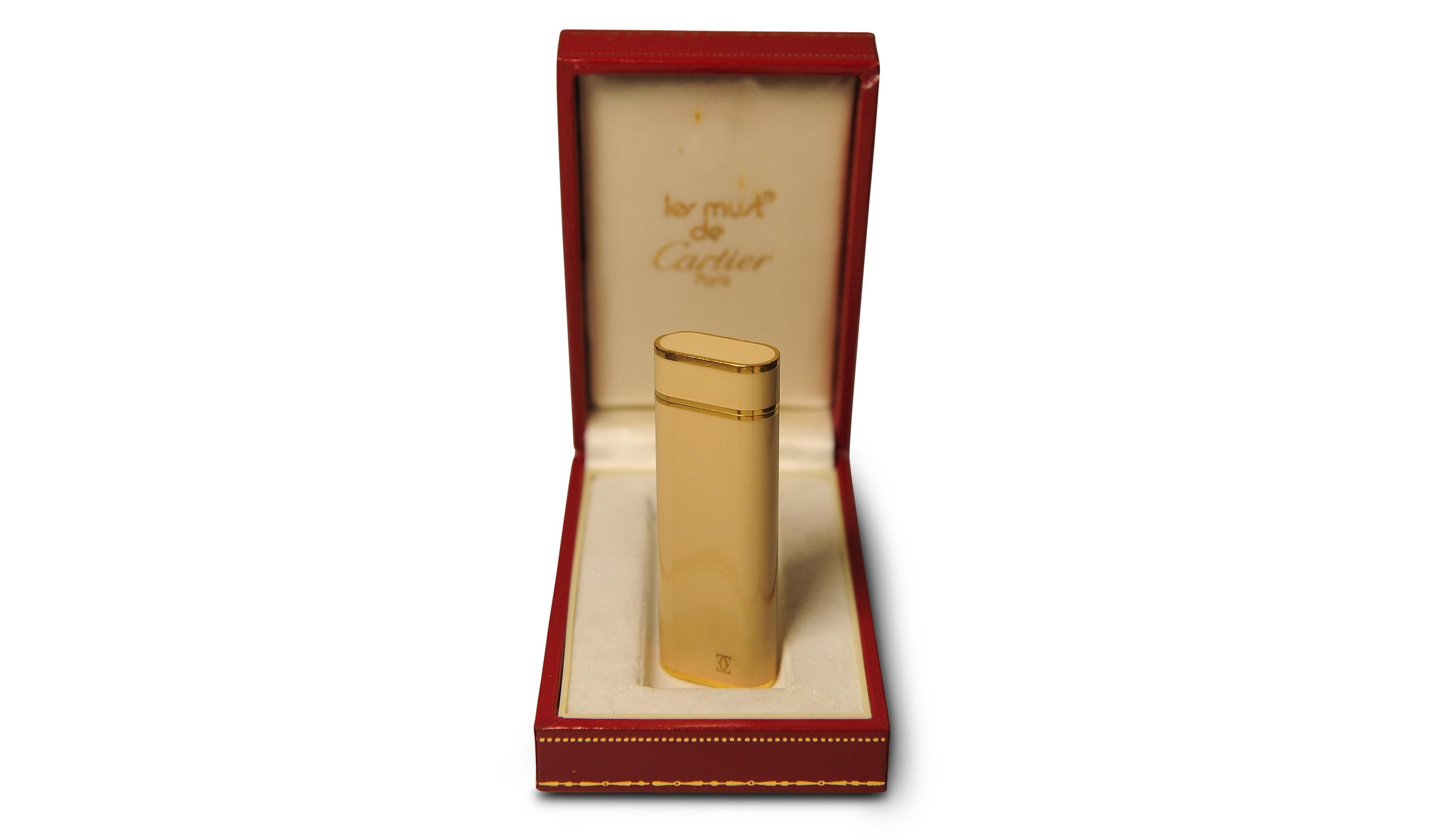 Un elegante accendisigari Cartier placcato in oro 18 ct. con smalto nudo, scatola e garanzia Cartier

L'accendino è stato revisionato

Marcato Cartier Paris alla base dell'accendino 

Completo di scatola originale

