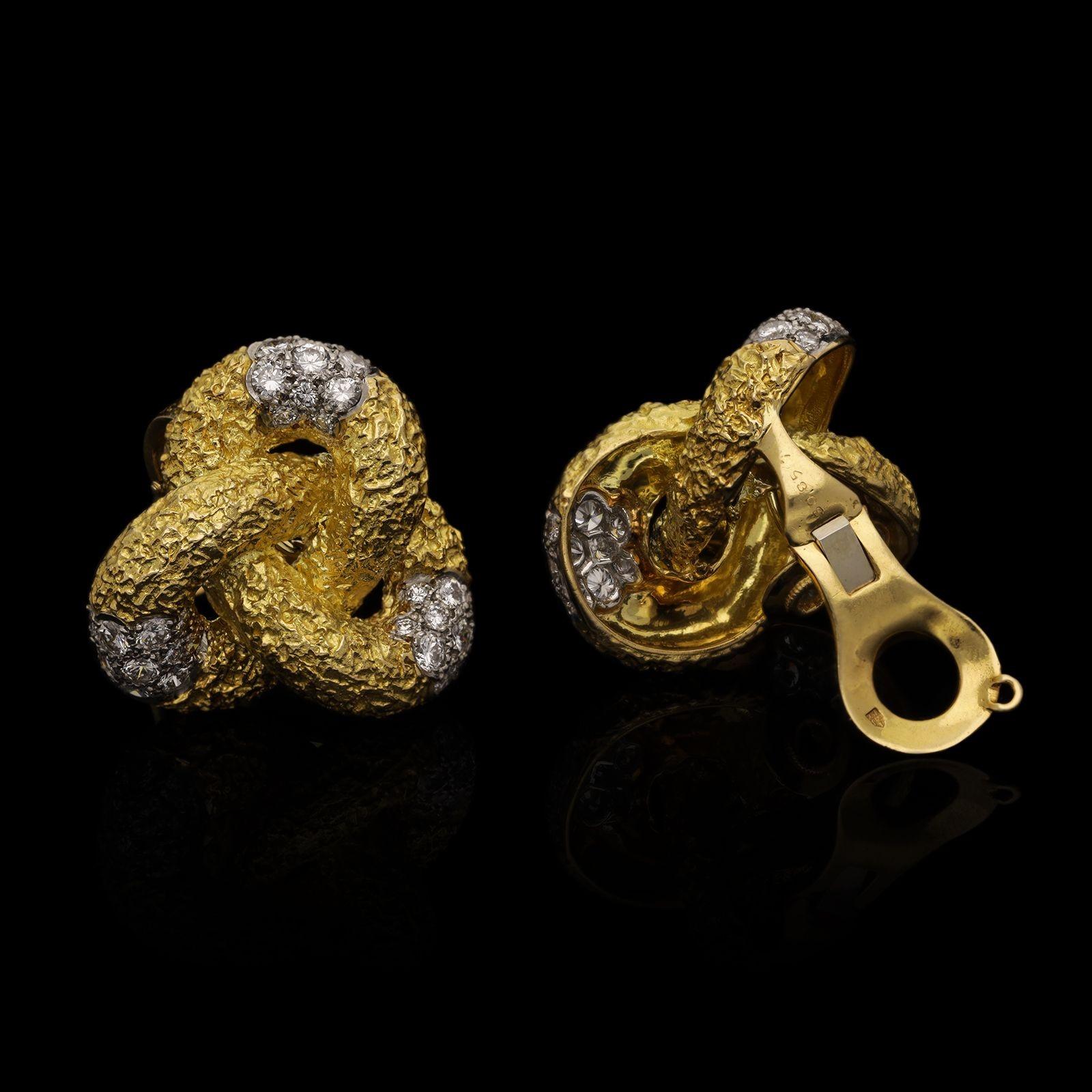 Paire de boucles d'oreilles vintage en or et diamants par Cartier dans les années 1960, chacune conçue comme un nœud à trois lobes en or jaune 18ct fortement texturé, le segment central de chacune est pavé de diamants ronds de taille brillant, le