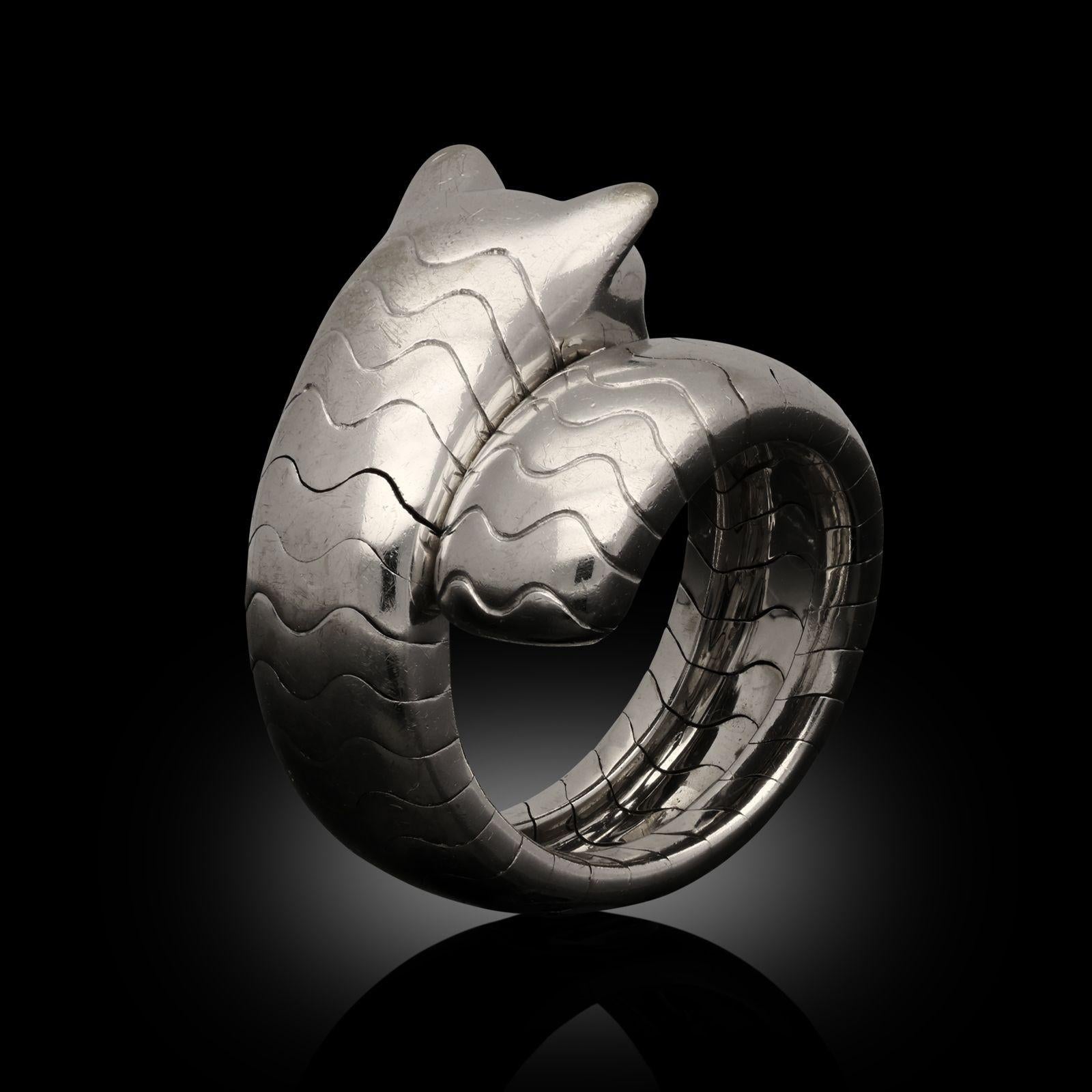 An 18ct white gold Panthère ring by Cartier, circa 2000s from the ‘Panthère Lakarda’ collection. The panther’s stylised design wraps around the finger and the wide band is lightly sprung to fit comfortably and can accommodate more finger sizes. The