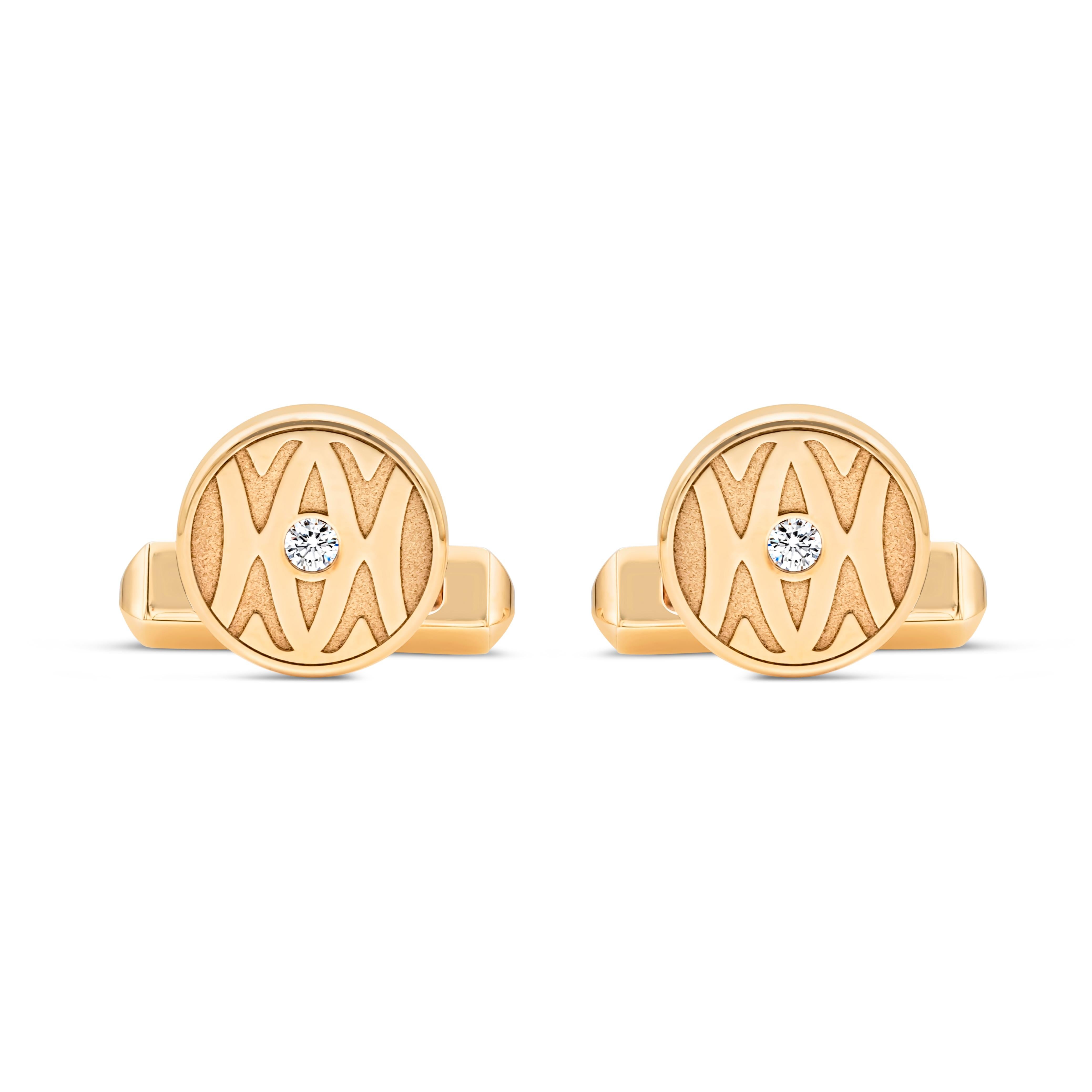 A dashing pair of cufflinks created by Cartier, featuring round brilliant cut diamonds weighing 0.14 carat total with E color and VS clarity set in the middle of an 18K yellow gold round face. These cufflinks feature the famous Cartier logo and a