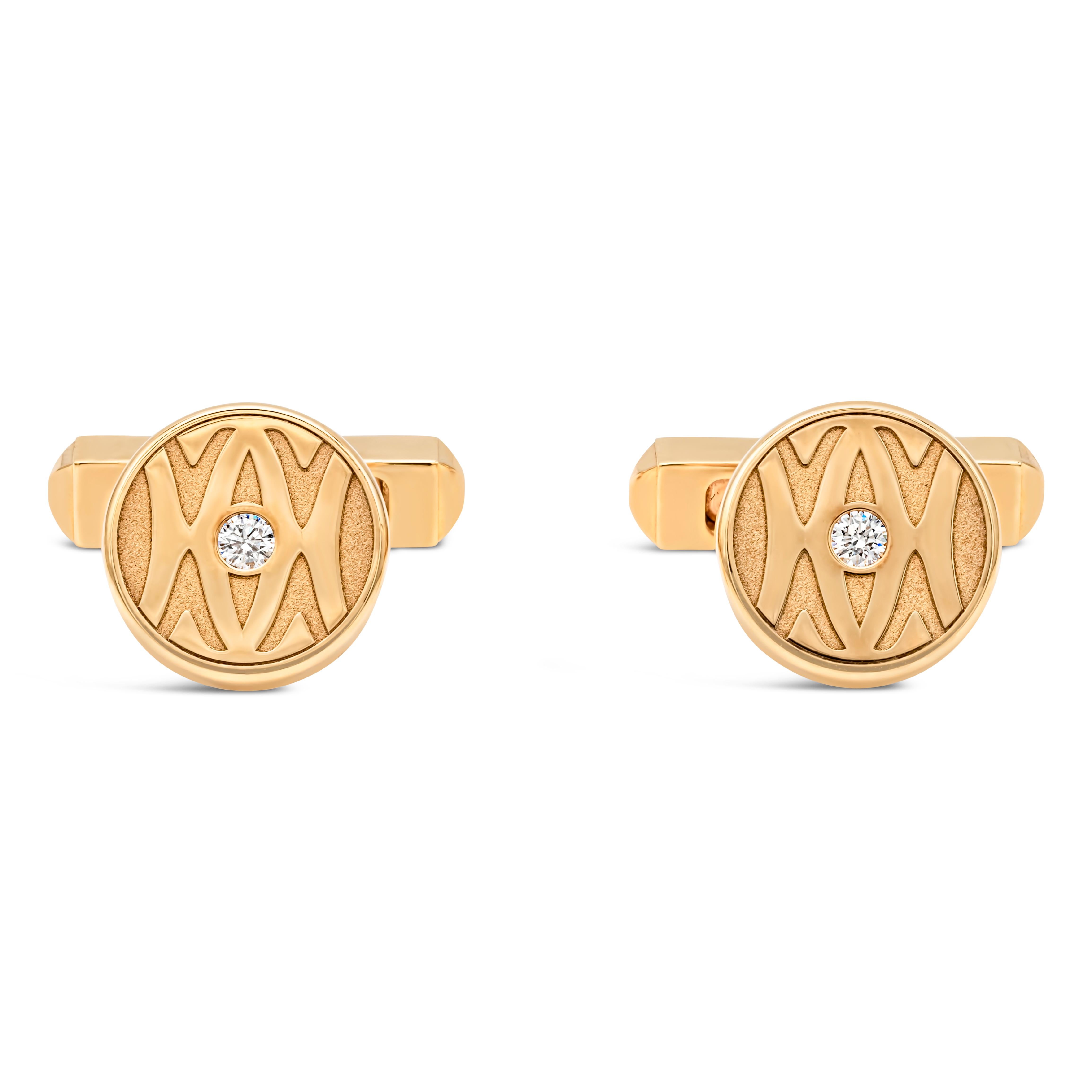 A dapper pair of cufflinks created by Cartier, featuring round brilliant cut diamonds weighing 0.14 carat total with E color and VS clarity set in the middle of an 18K yellow gold round face. These cufflinks feature the famous Cartier logo and a