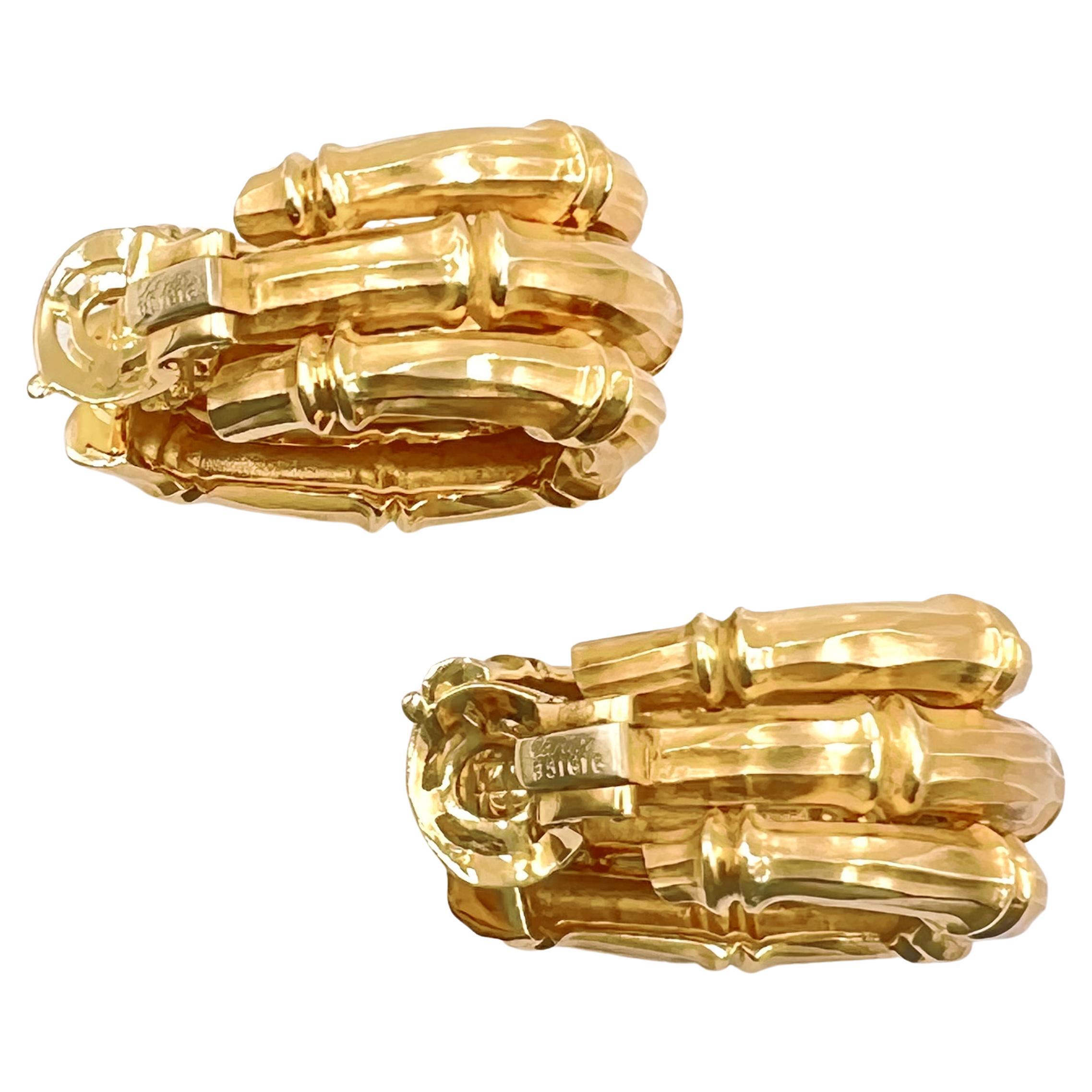 Large half-hoop earrings, designed as three vertical rows of bamboo stalks in matte-finished 18 yellow gold.  Hinged clip backs.  Signed 'Cartier' with serial number and French gold mark  Circa 1978.  Earring dimensions: 1.5
