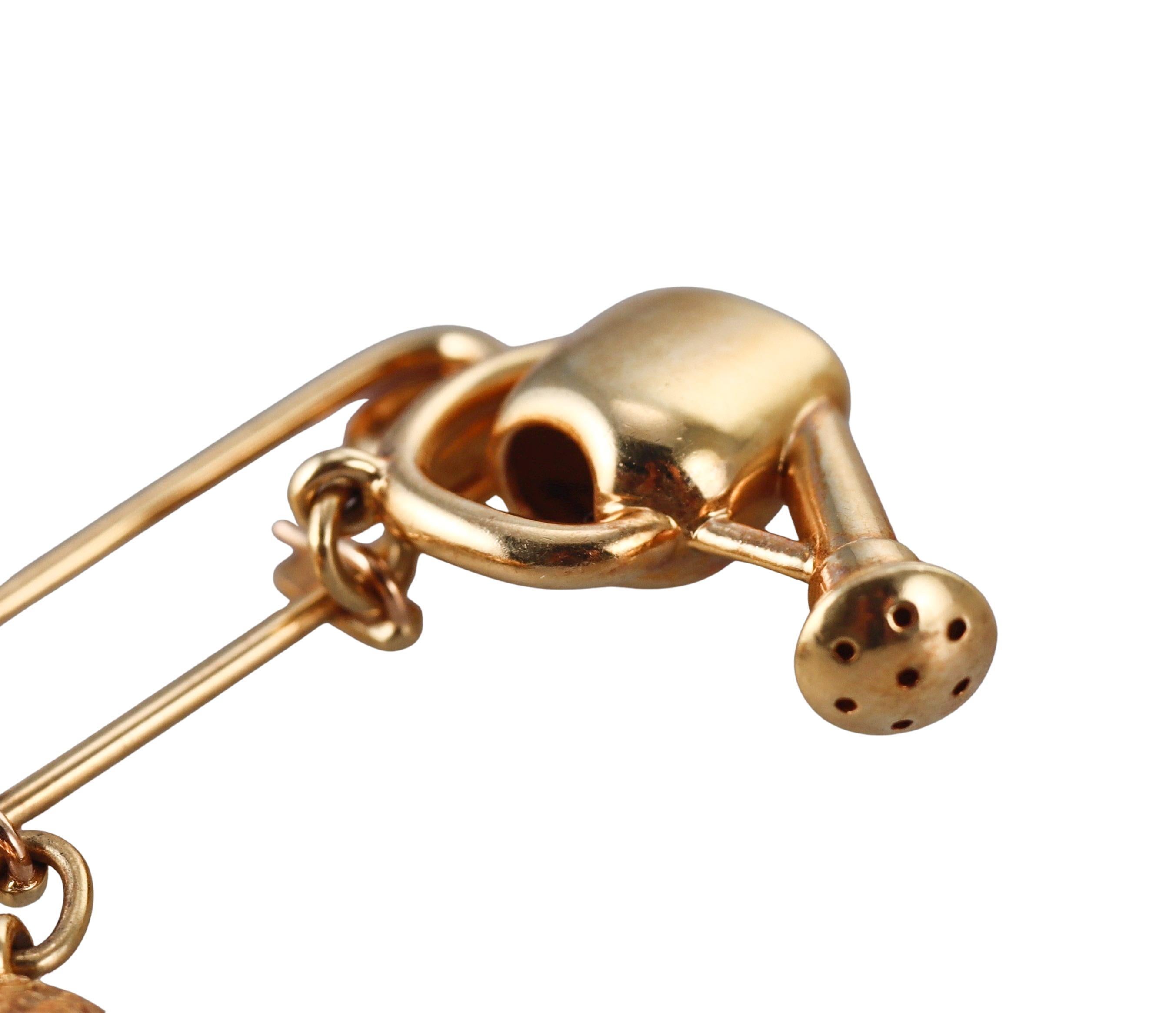 Cartier 18k gold brooch, featuring gardening tool charms - watering can, a hat and a wheelbarrow. Charms are detachable.
Brooch overall measurements are 1.5