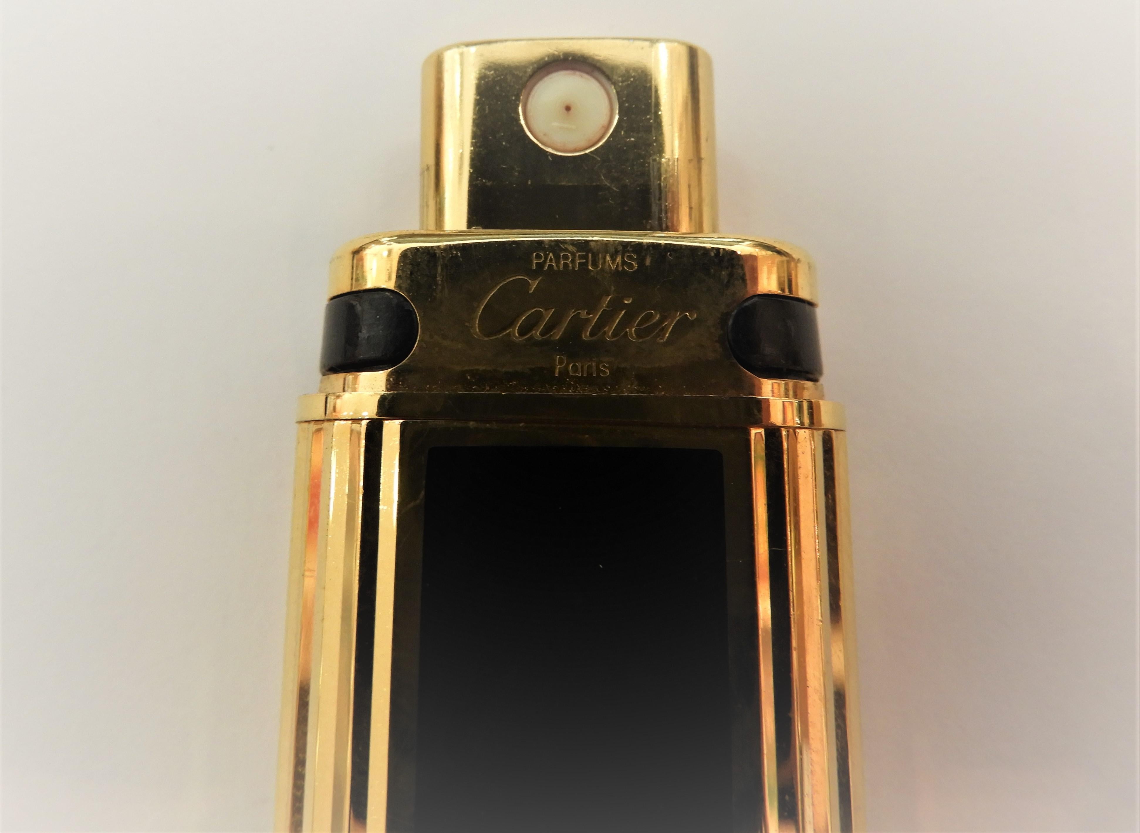 CARTIER NÉCESSAIRES À PARFUM - Pocket Fragance Case   in 18-karat gold-plated and black enamel 
It has an adjustable top lid that houses the Swiss-made mechanism. 
It is marked on its both with cover and base with Cartier 
Dimensions
Height: 4 in.