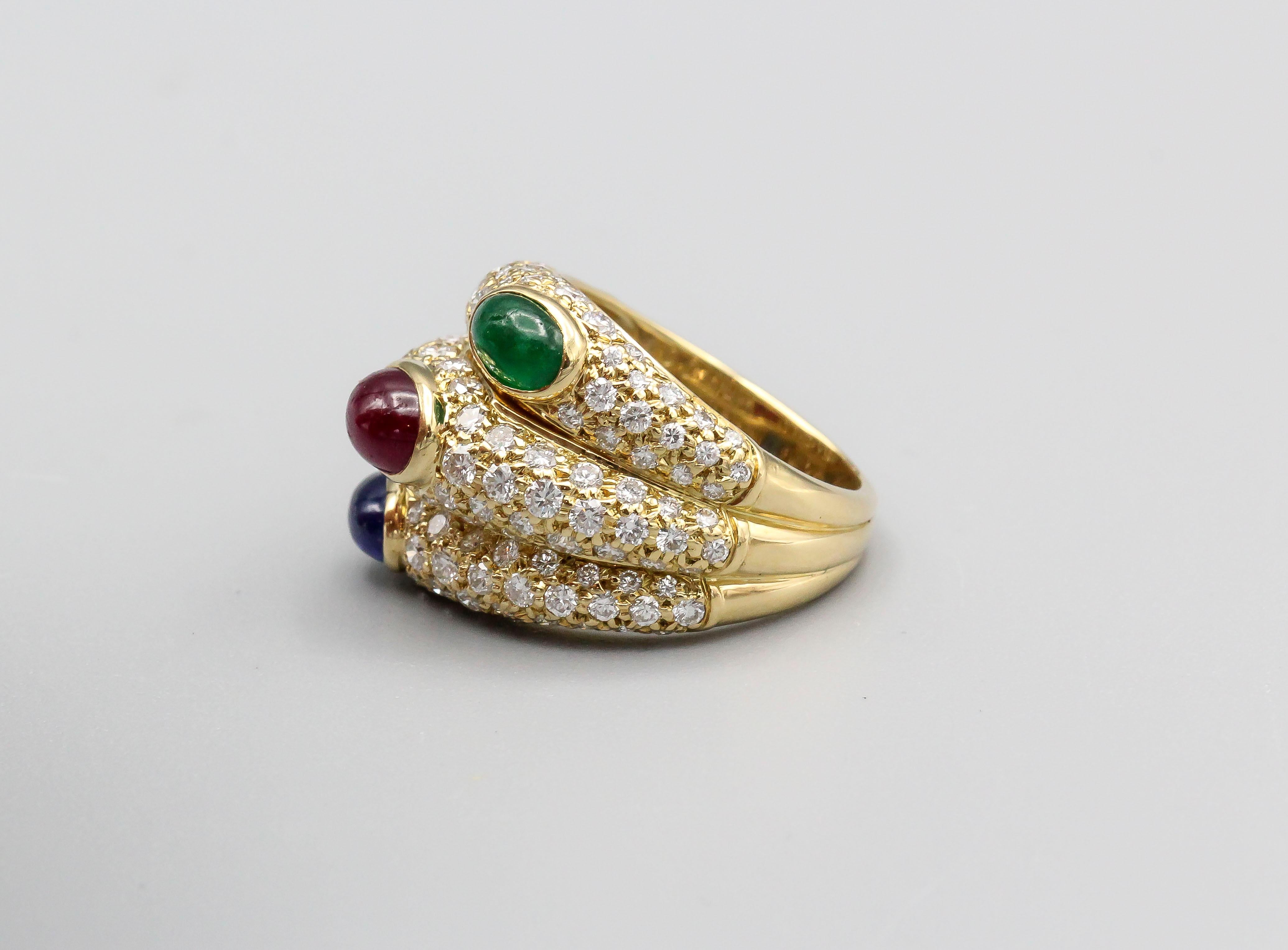 Fine 18k yellow gold ring with pave set diamonds and a combination of sapphire, ruby, and emerald cabochon stones, by Cartier. The design of the ring is made to look like three rings stacked on top of one another with each colored stone cabochon